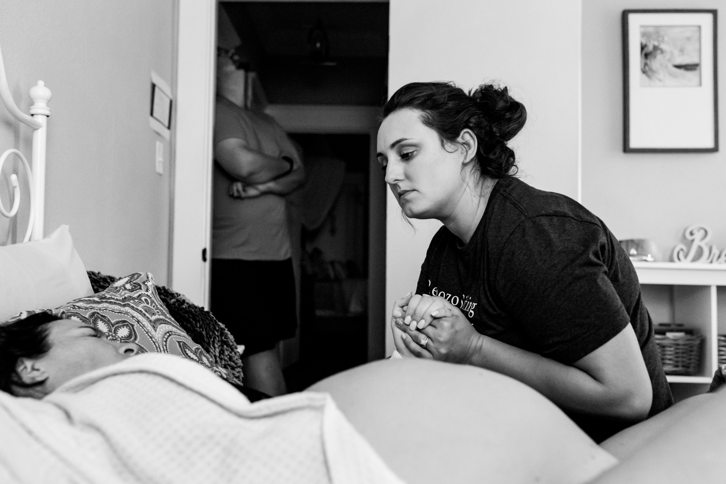 doula holding the hand of her laboring client