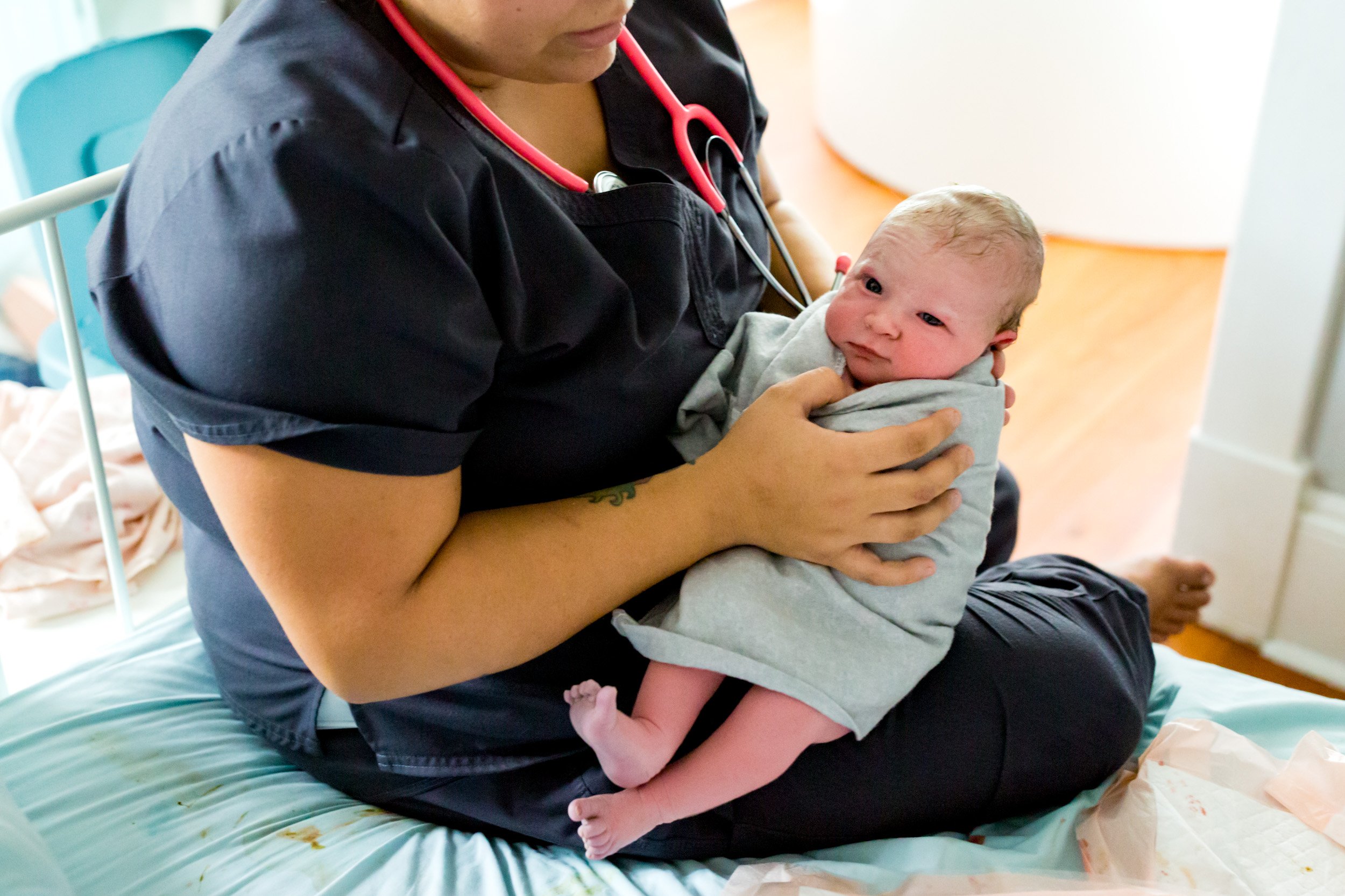 midwife holding baby on her lap