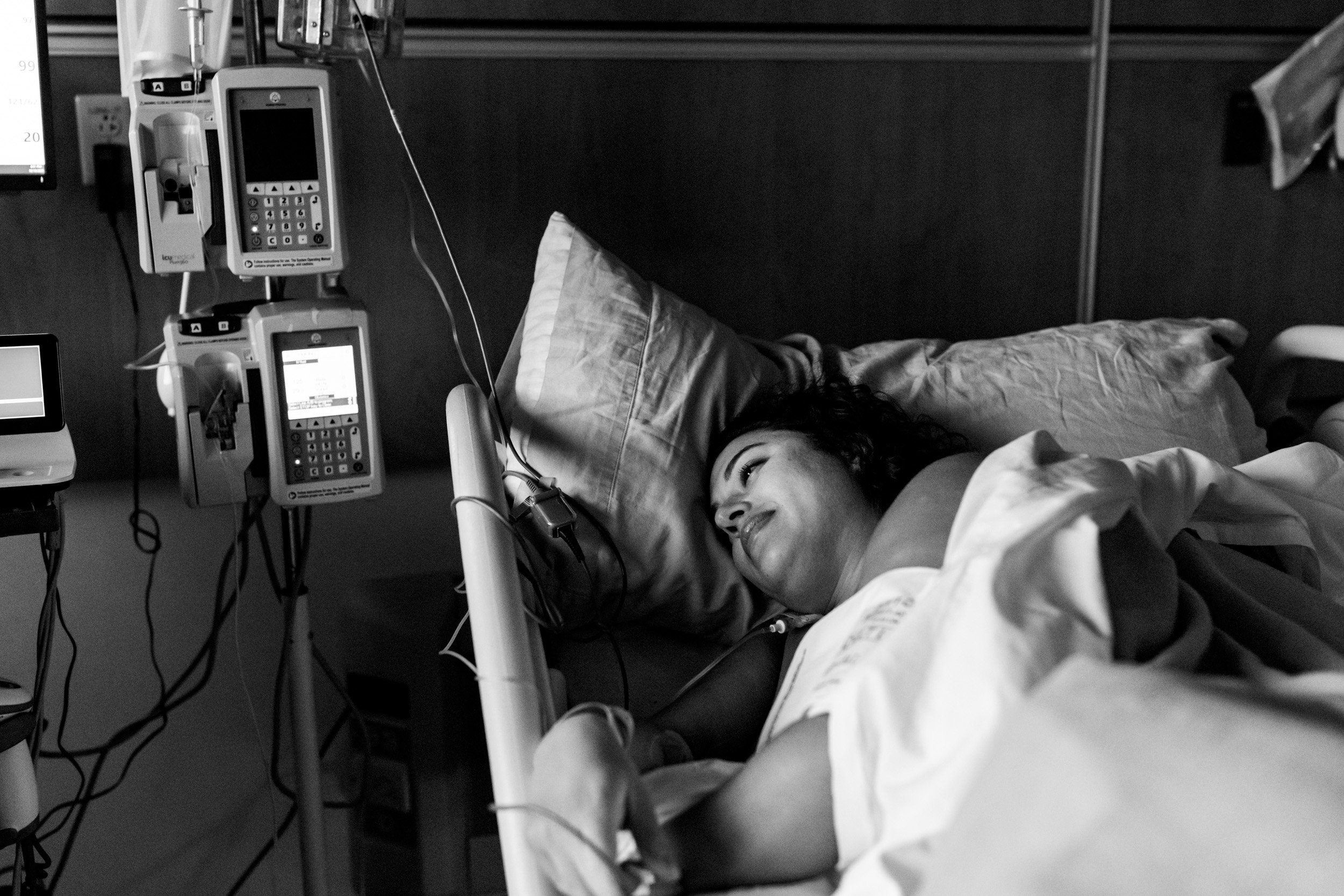 birth mom with a smile on her face in the hospital bed