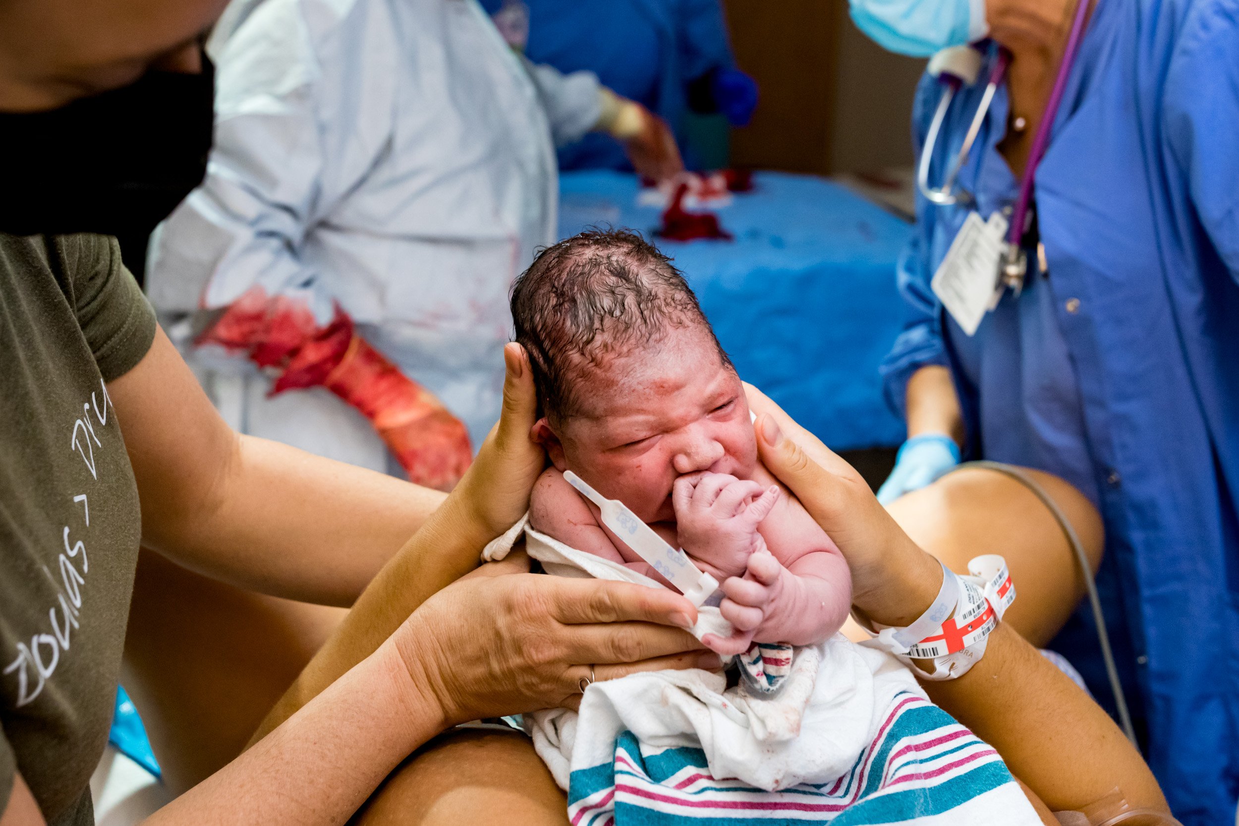 birth mom holding up her newborn baby