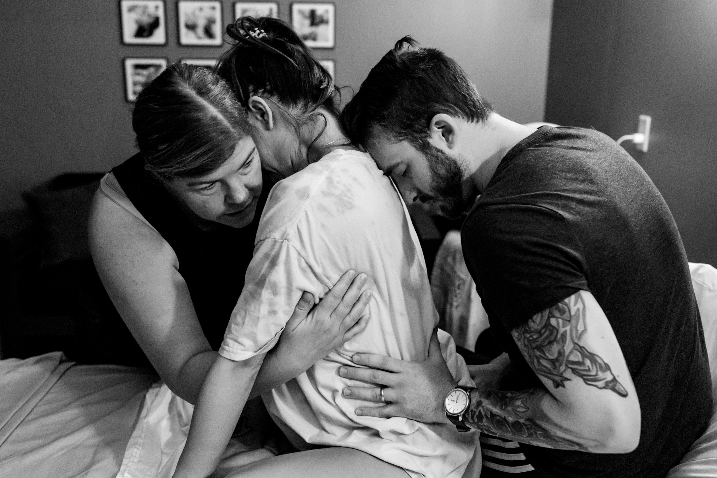 husband and doula supporting birth mom during a contraction