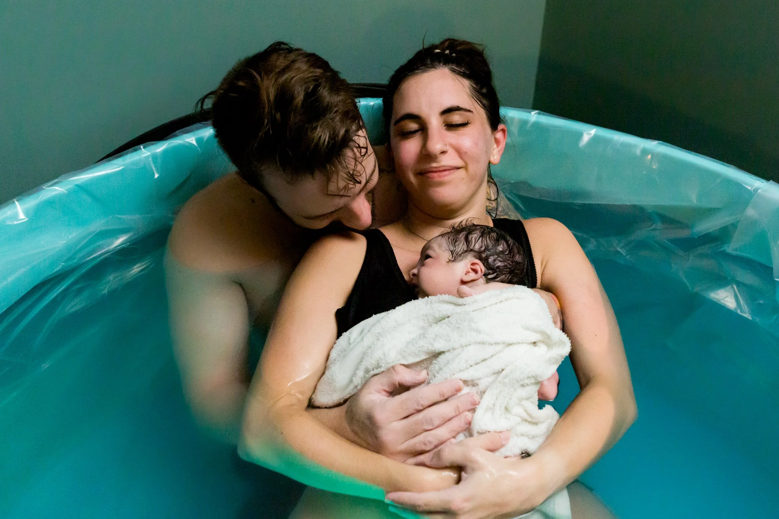 first time parents holding their baby girl just after birth