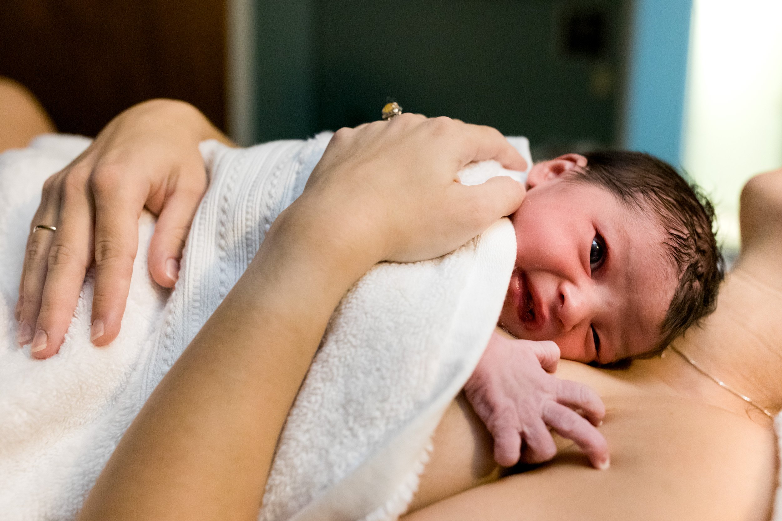 newborn baby girl skin-to-skin on her mama's chest