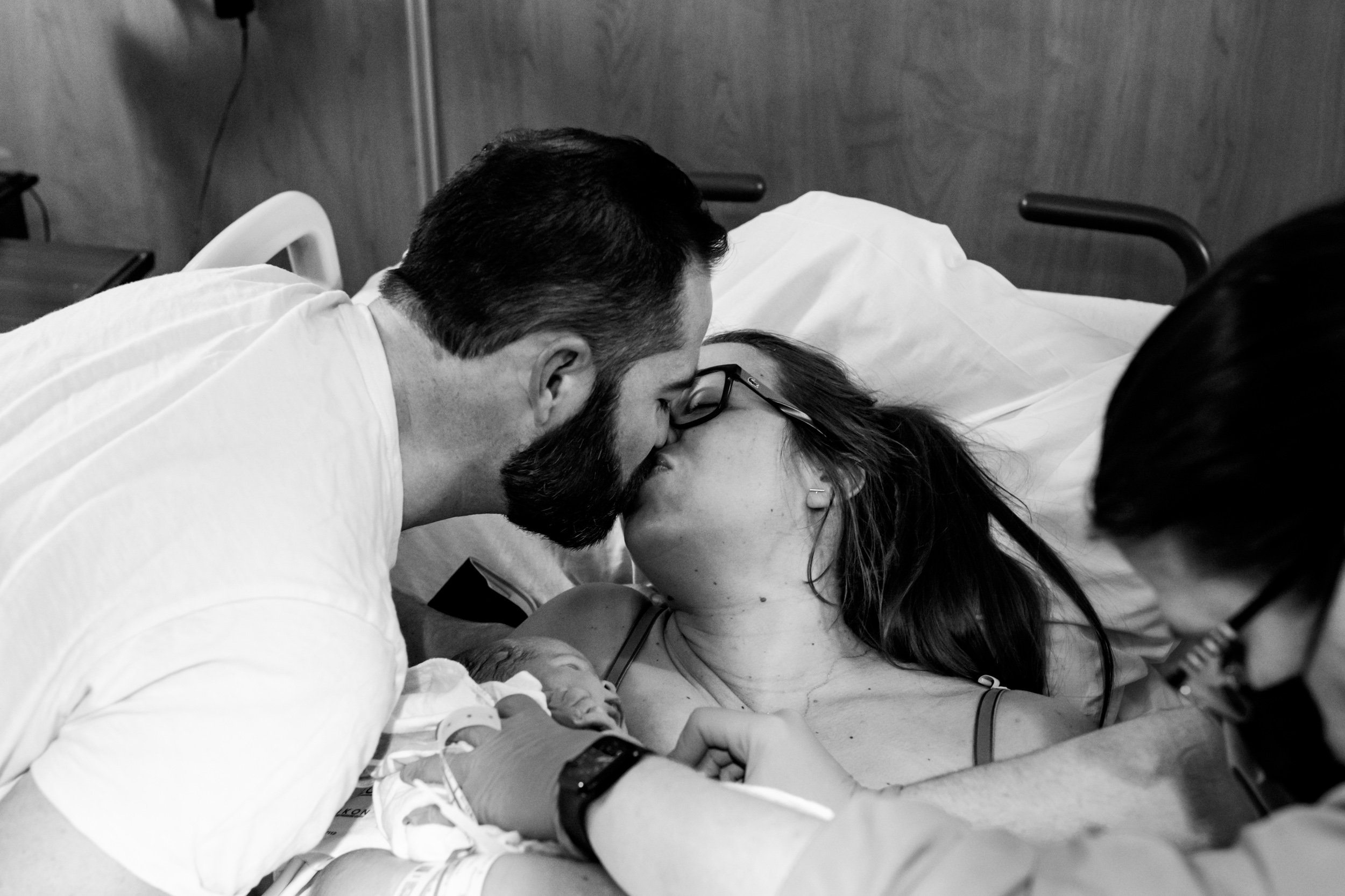 parents kissing after the birth of their baby girl
