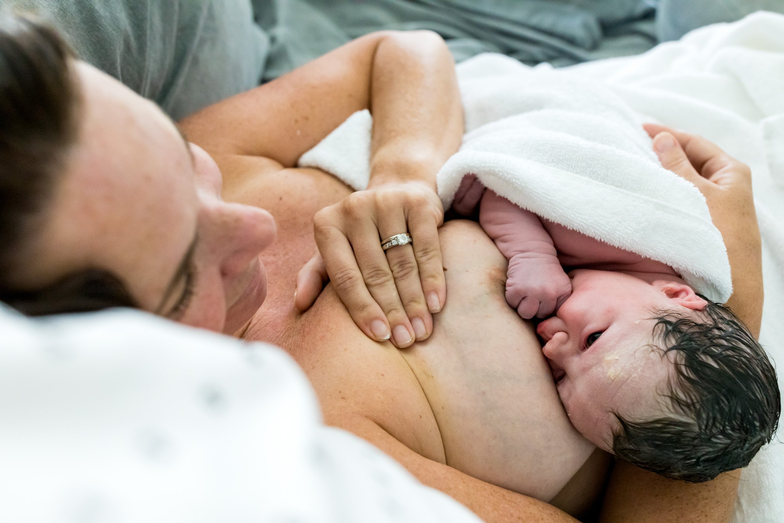 newborn baby resting on her mom's chest