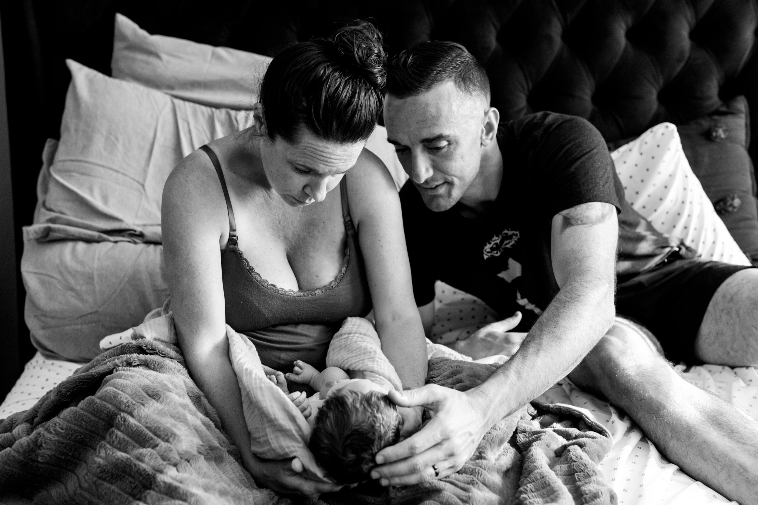 parents looking at their baby girl just after birth