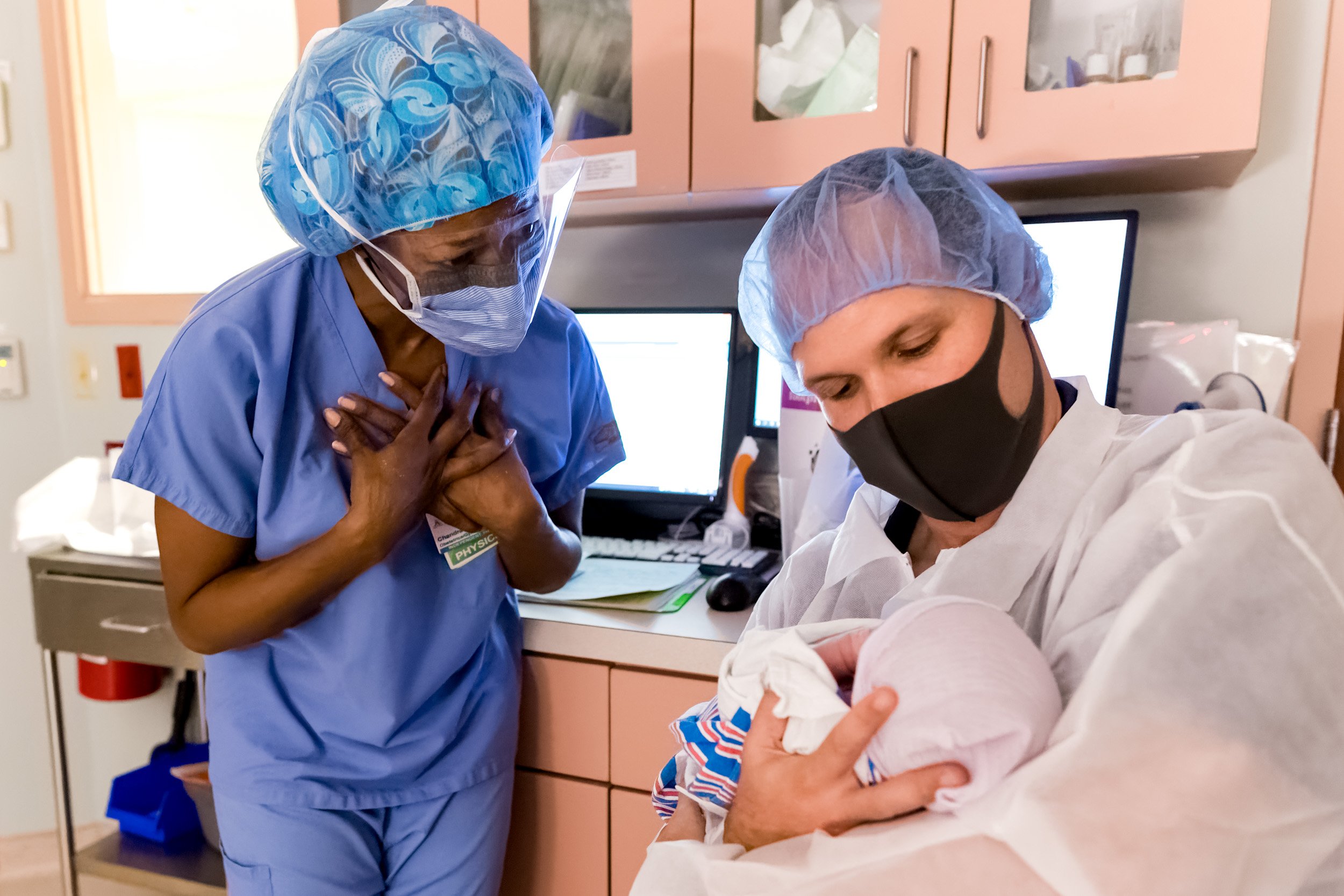 Dr. Adams of Full Circle Women's Care admiring newborn baby that she just delivered via c-section
