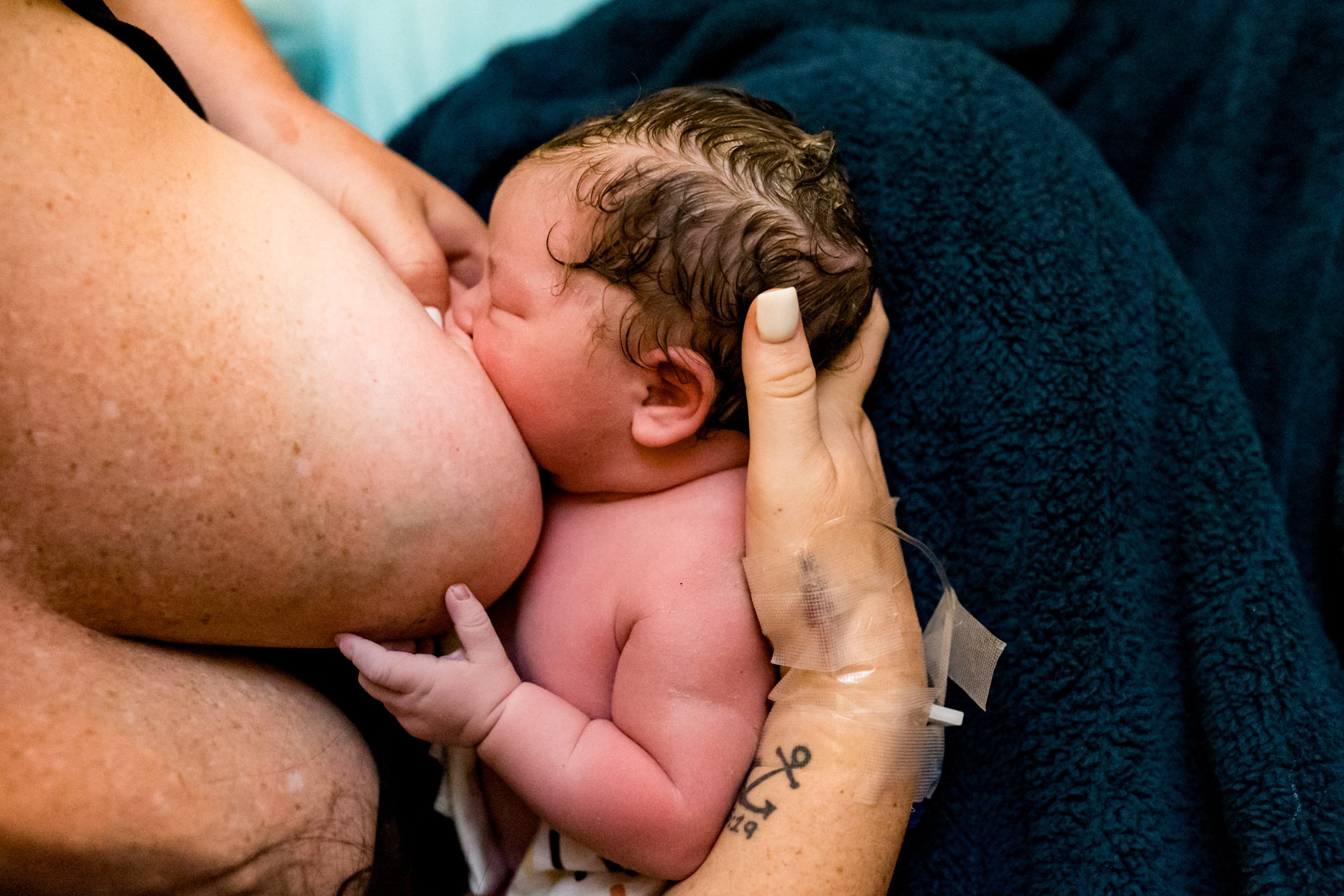 mom breastfeeding her baby girl just after birth