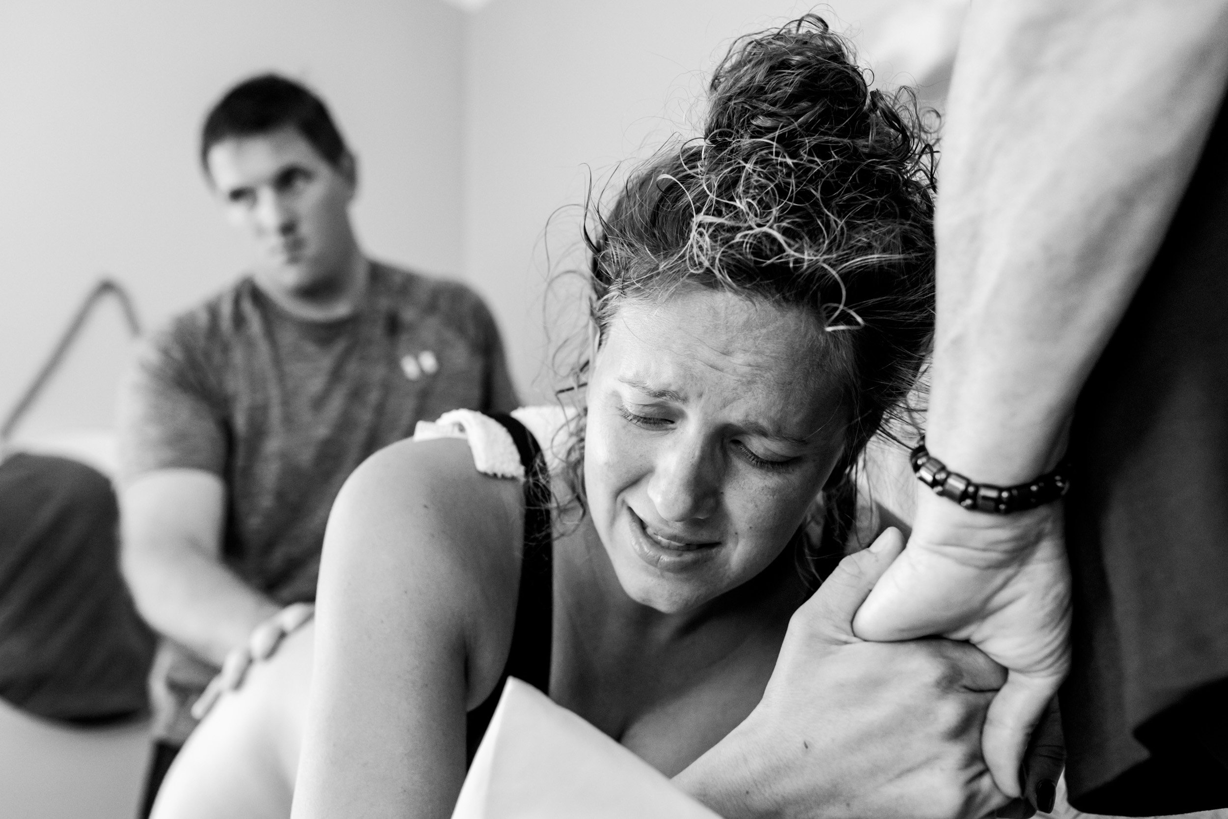 birth mom holding onto her mother's hands while having a contraction