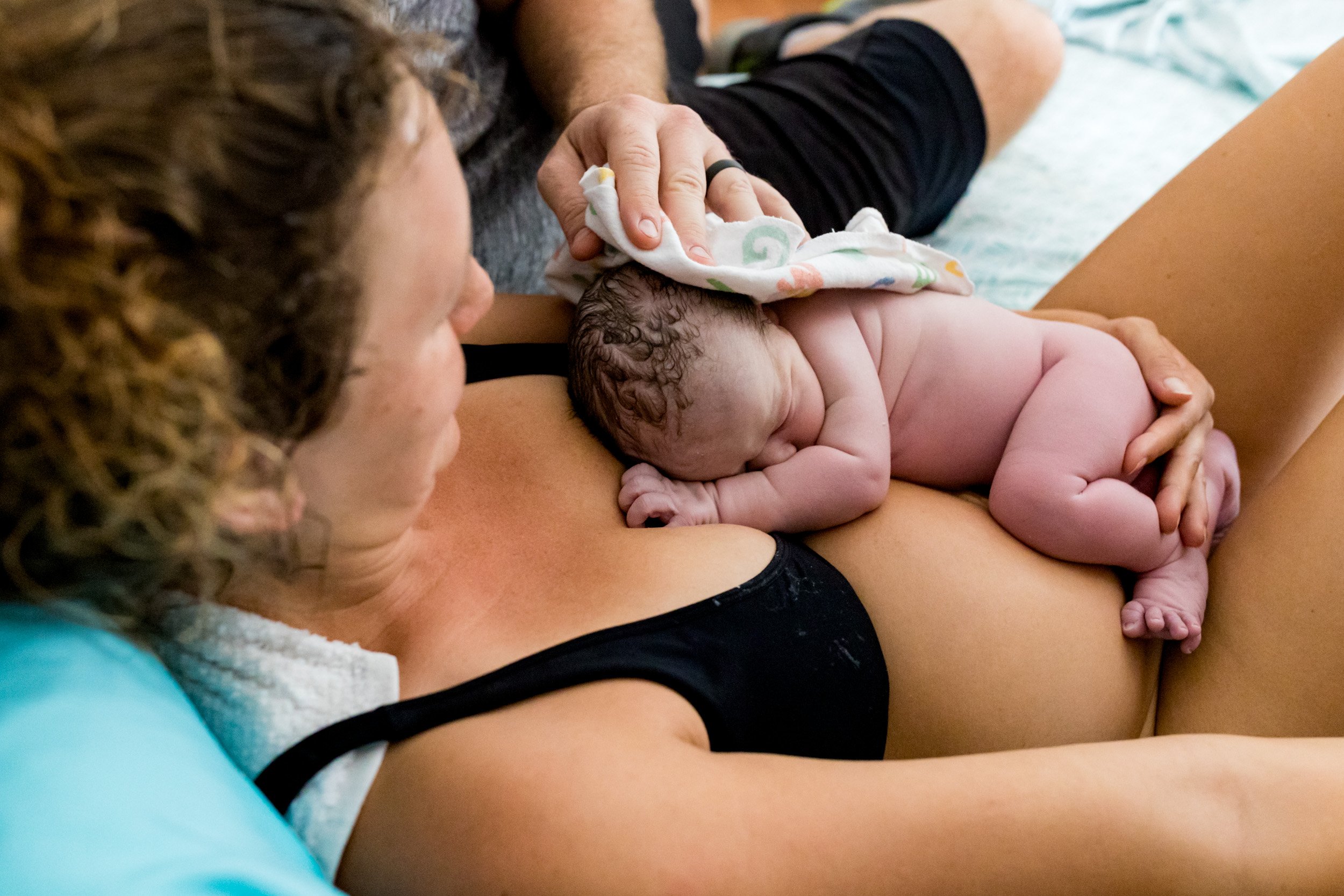 birth mom with her baby on her chest just after being born