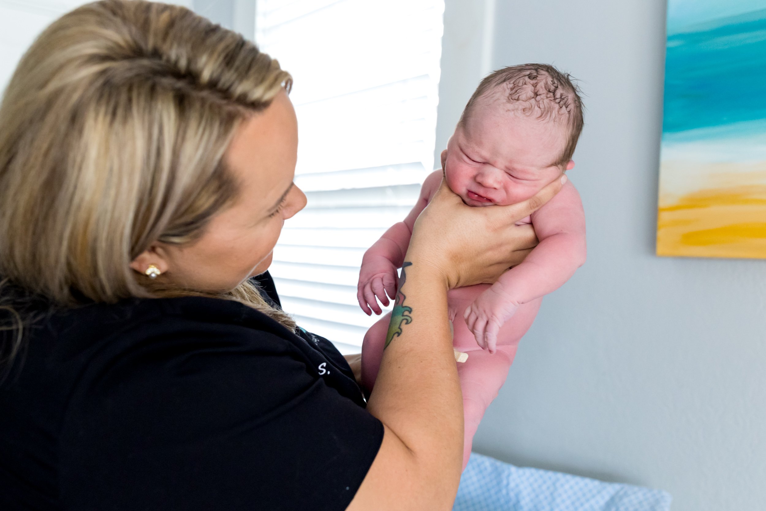 midwife holding newborn baby