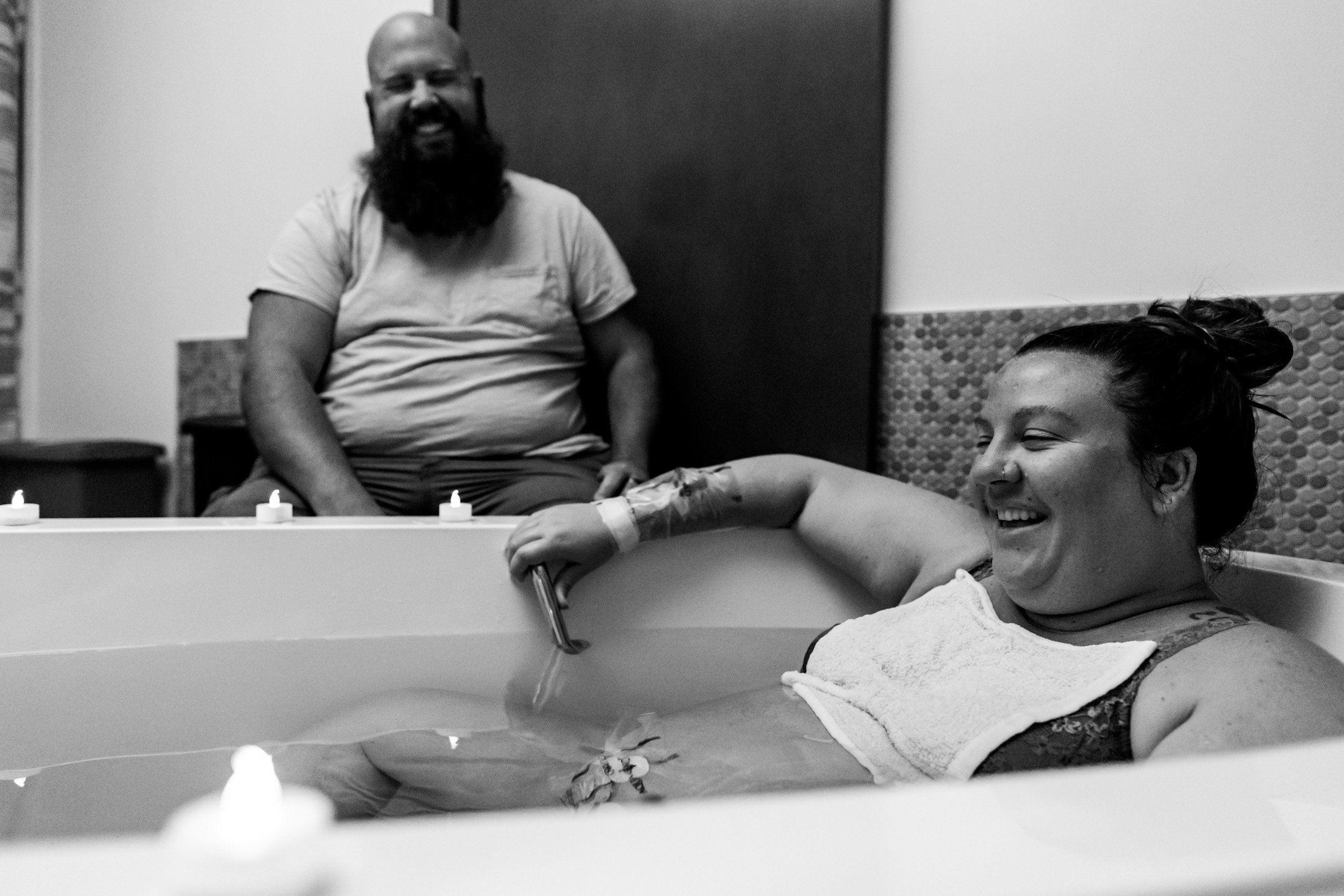 husband and wife laughing while between contractions