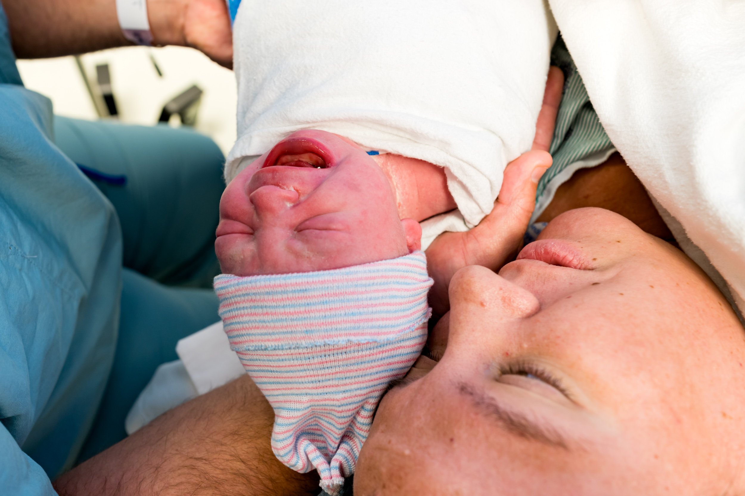 birth mom holding onto newborn baby girl in the OR