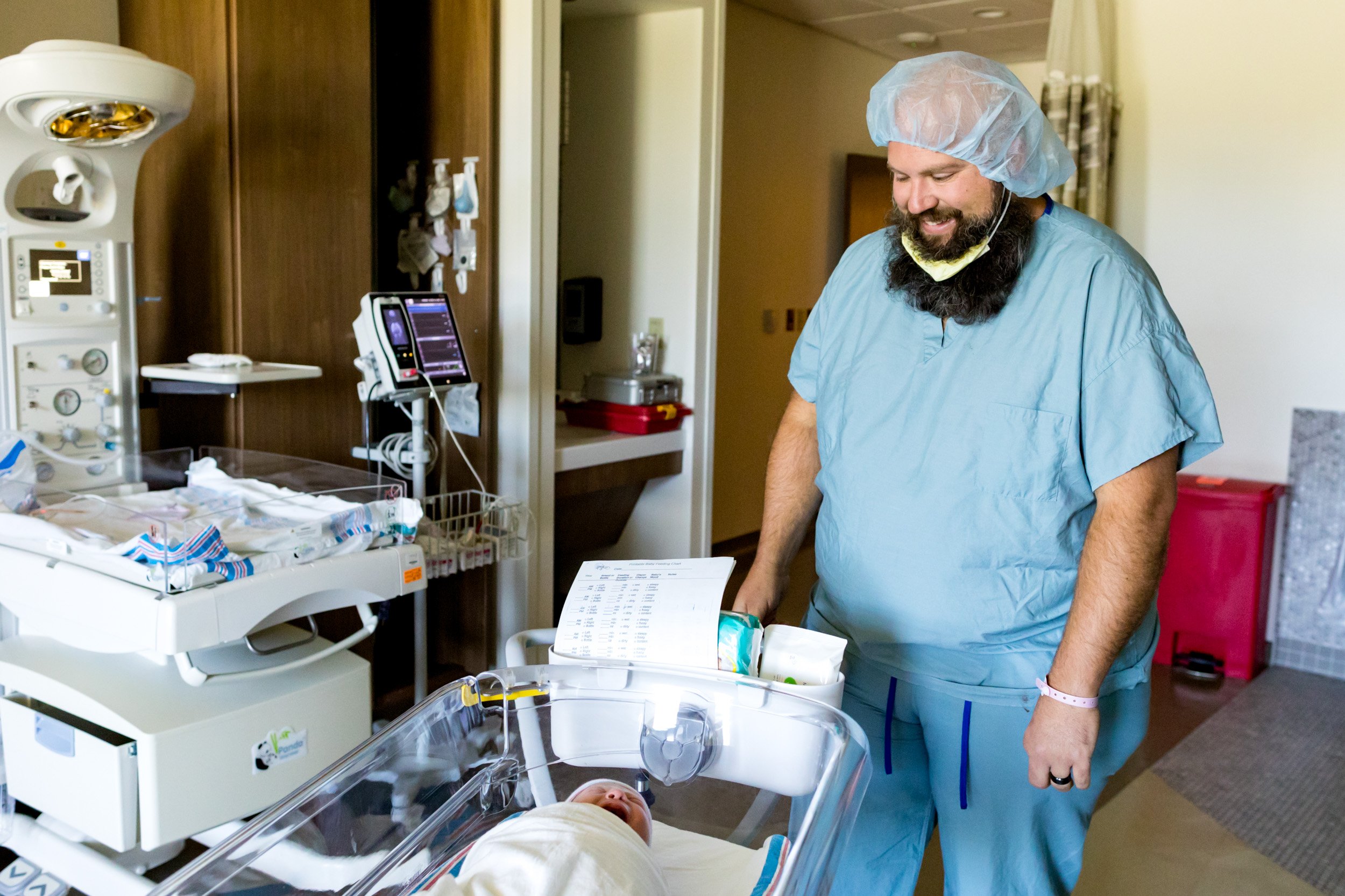 dad looking at his newborn baby girl