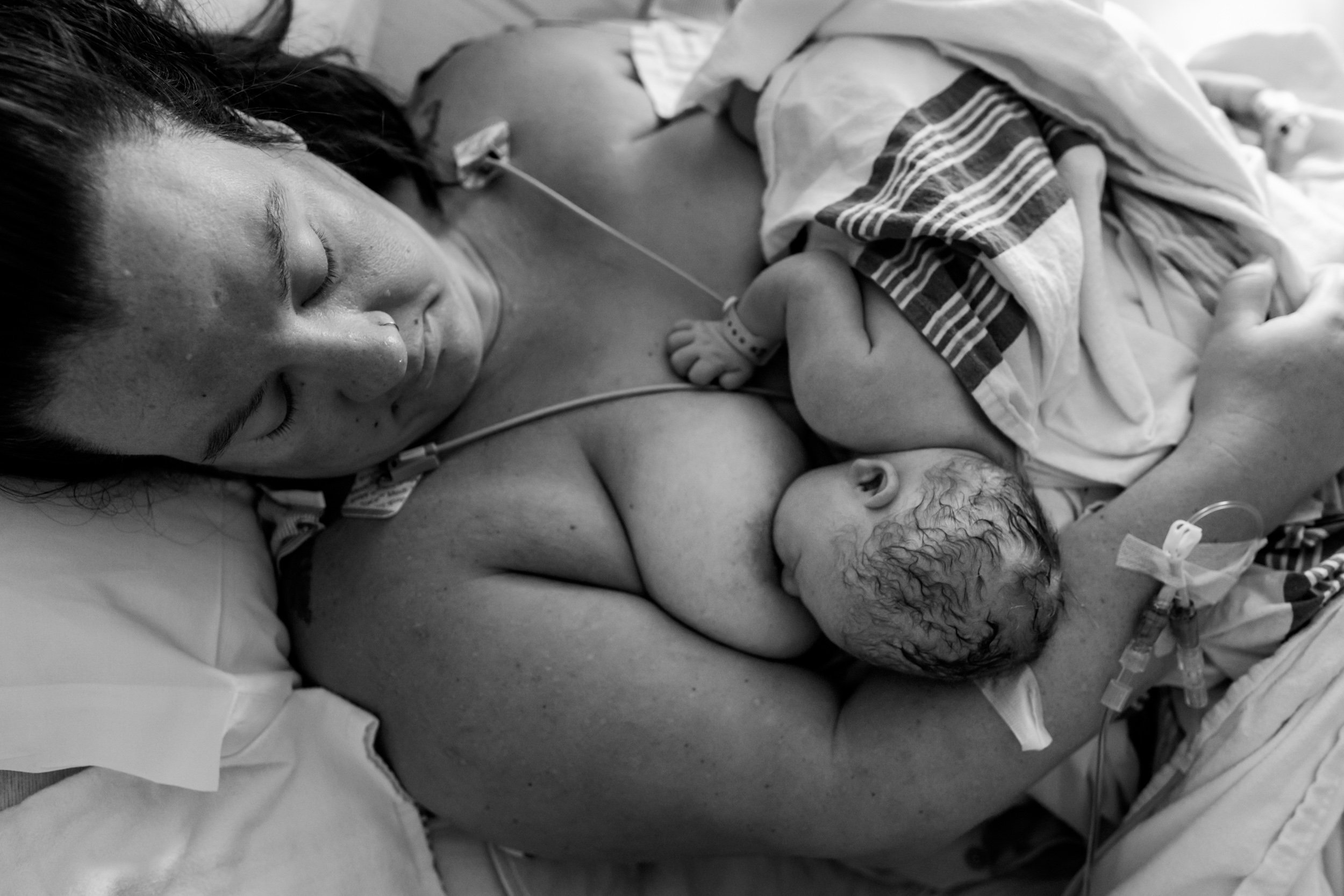 mom looking at her newborn baby while nursing