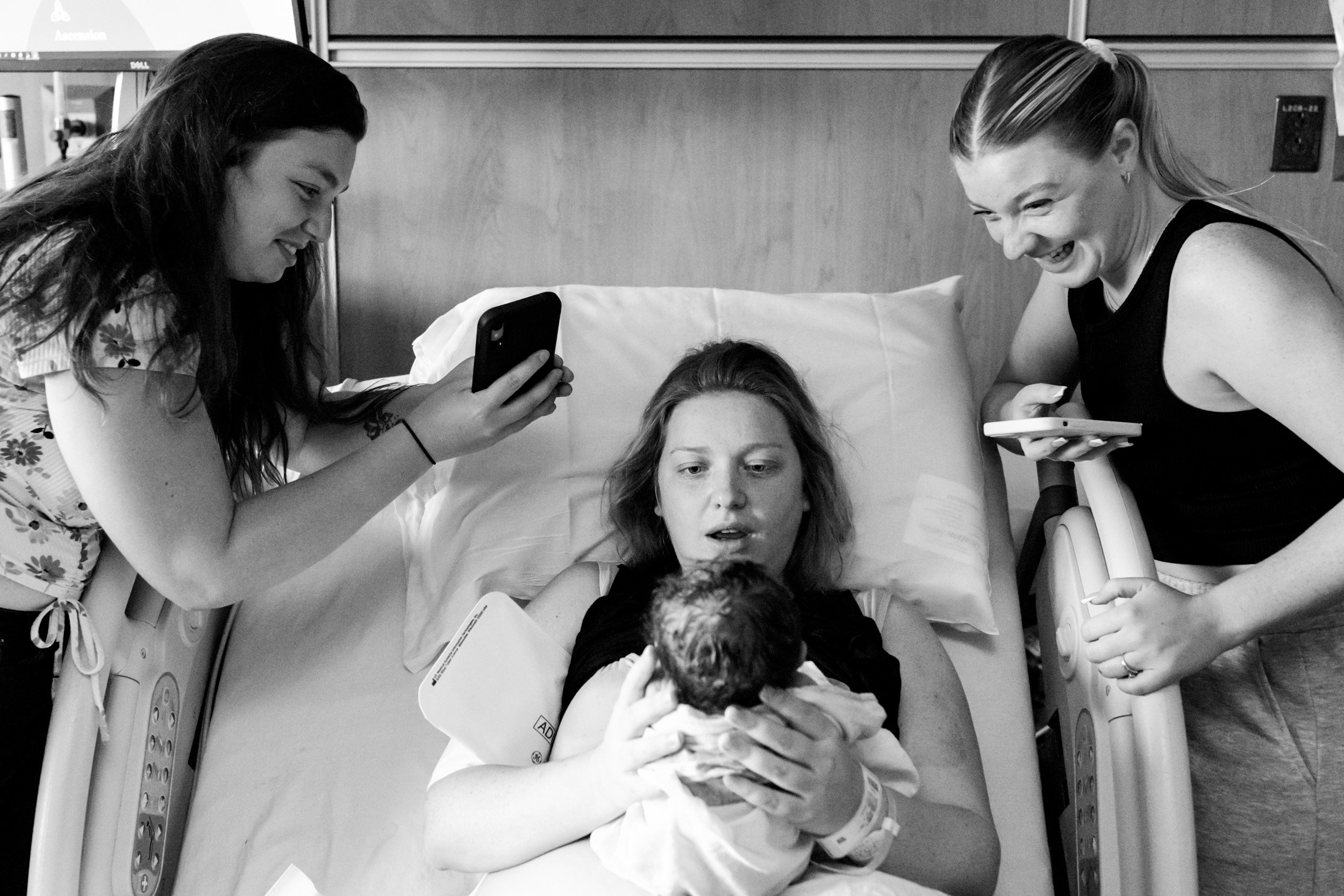 family looking at newborn baby and smiling