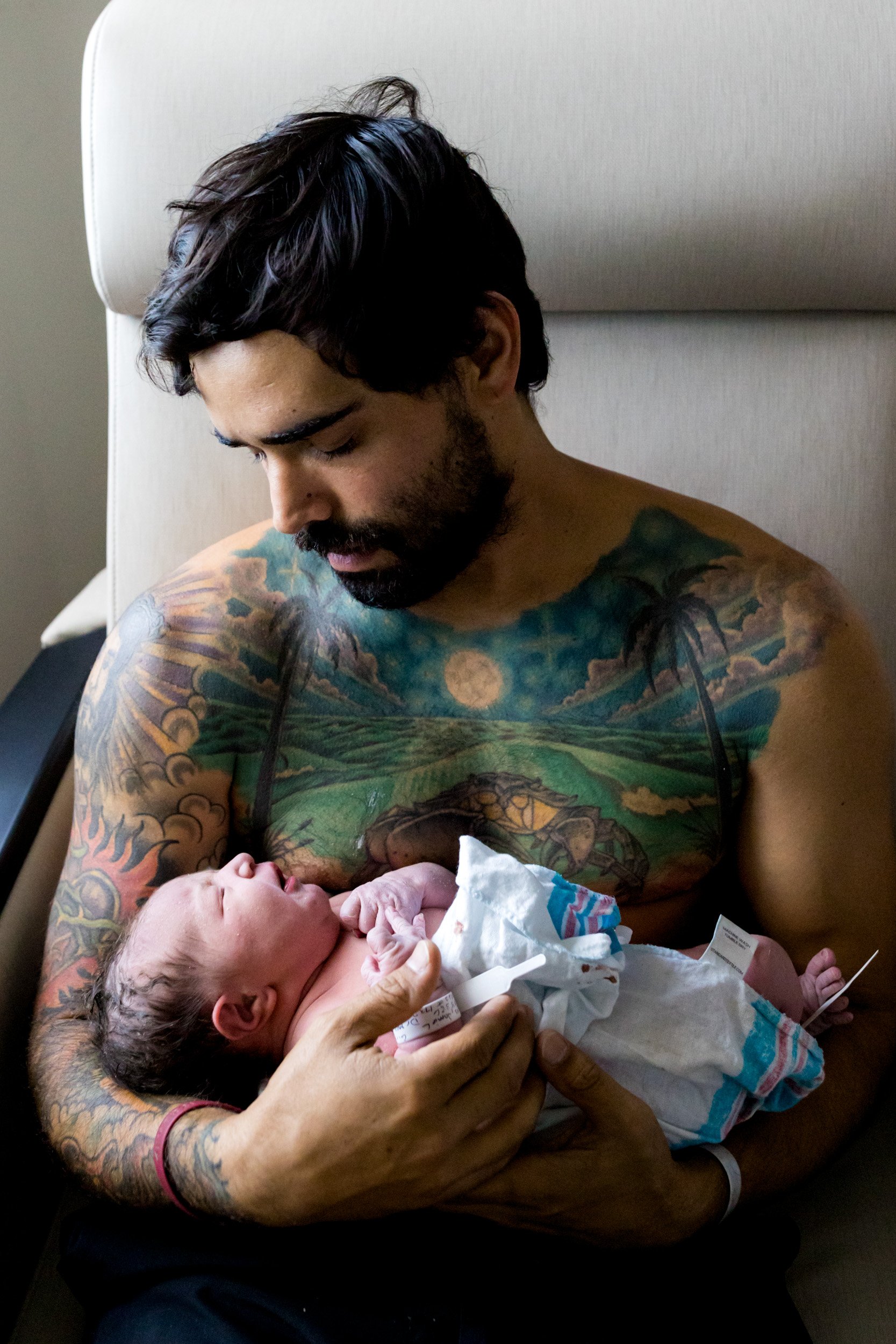 new dad holding his baby girl just after birth