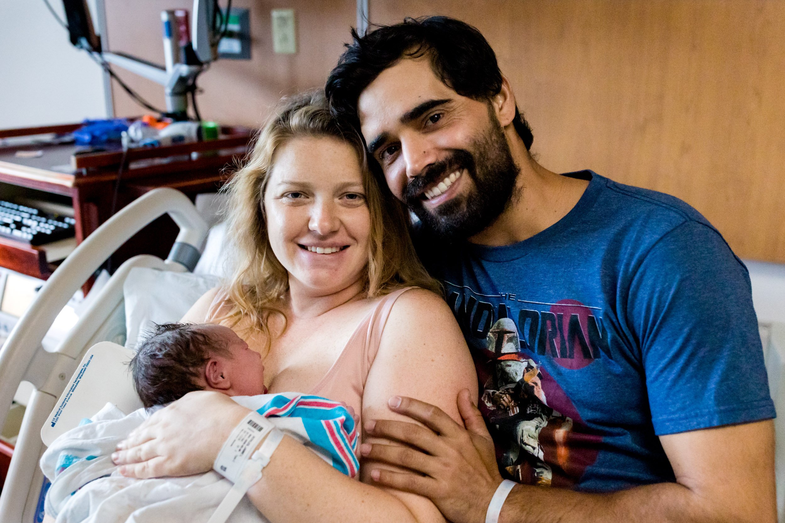 new family smiling and holding their baby girl just after birth