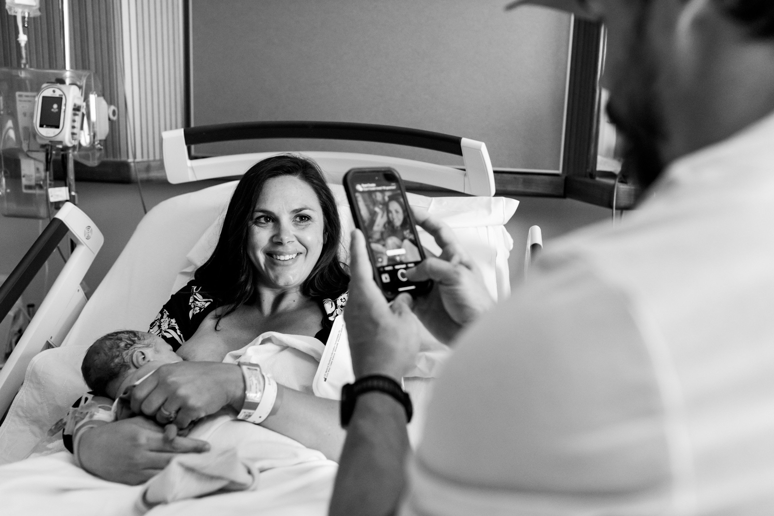 dad taking a picture of his wife holding their baby boy