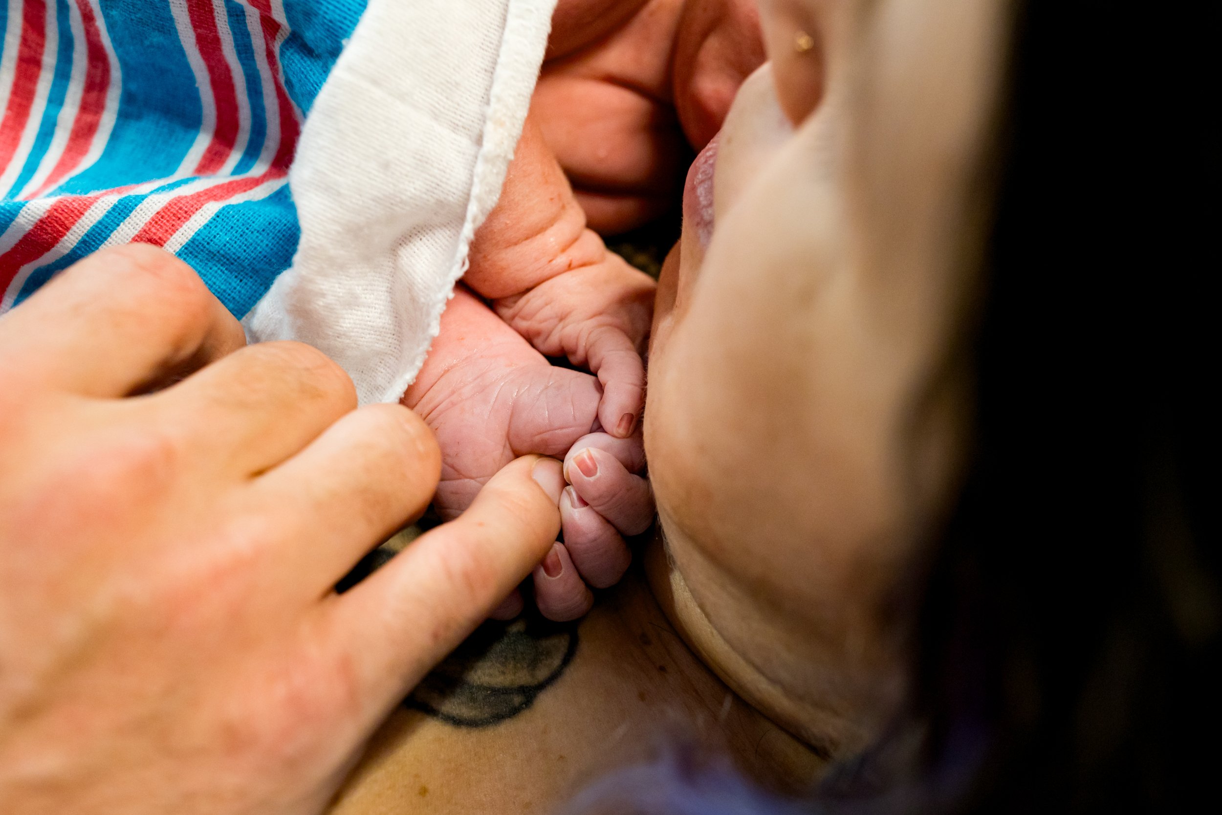 newborn baby gripping his dad's finger