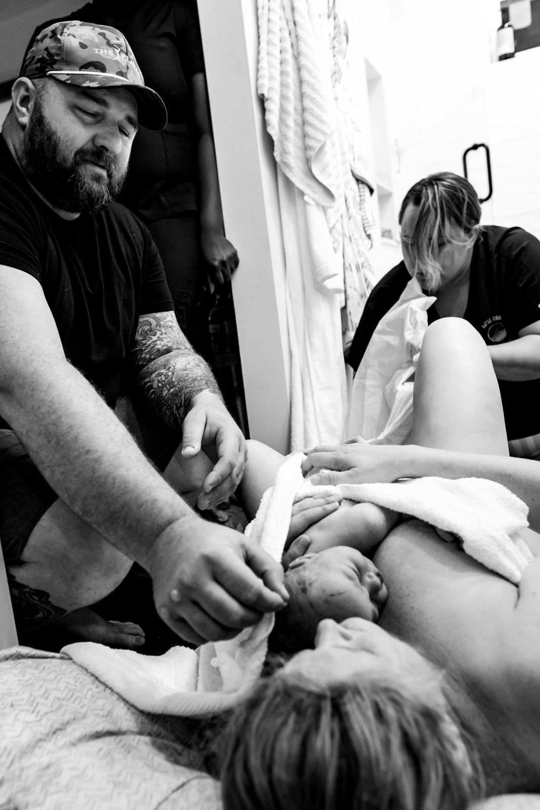 dad looking at his newborn baby girl and sweetly touching her head