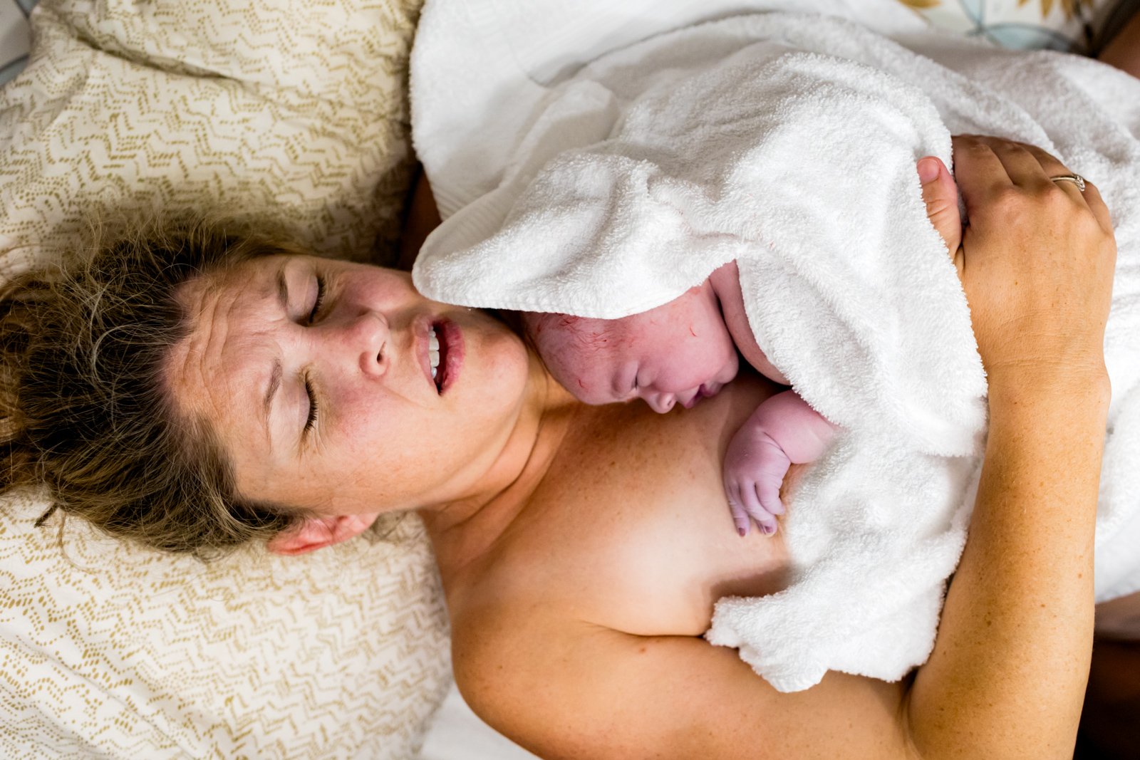 mom holding onto her baby for skin-to-skin just after birth