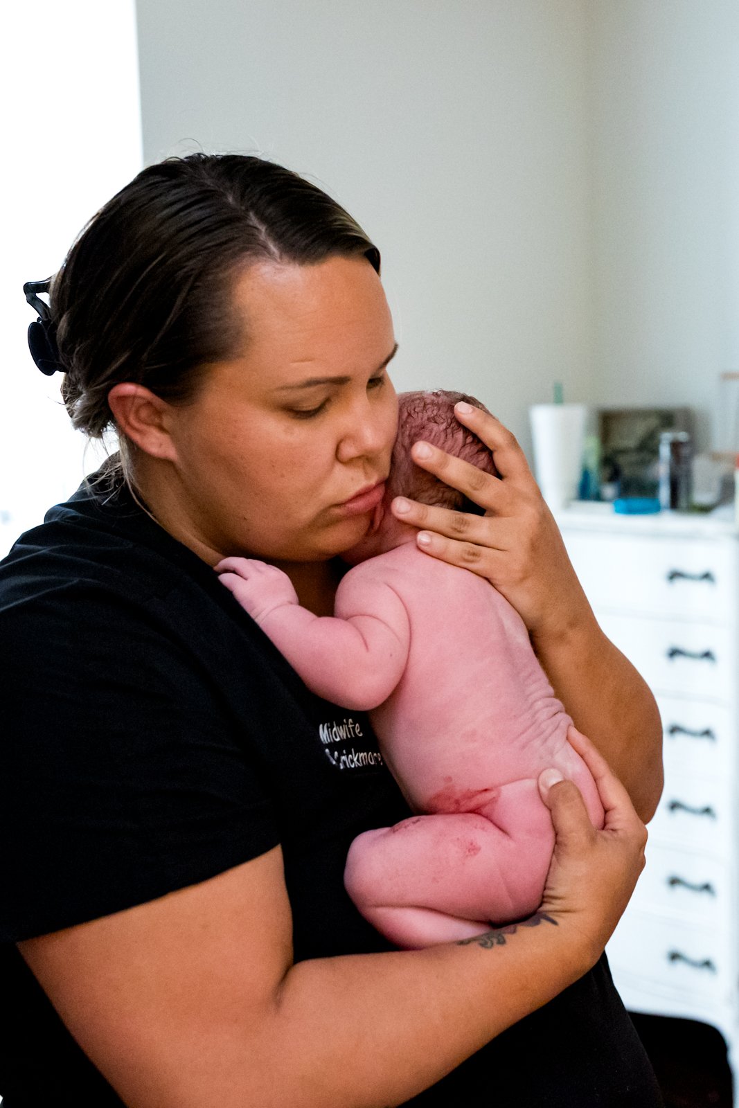 midwife holding newborn baby