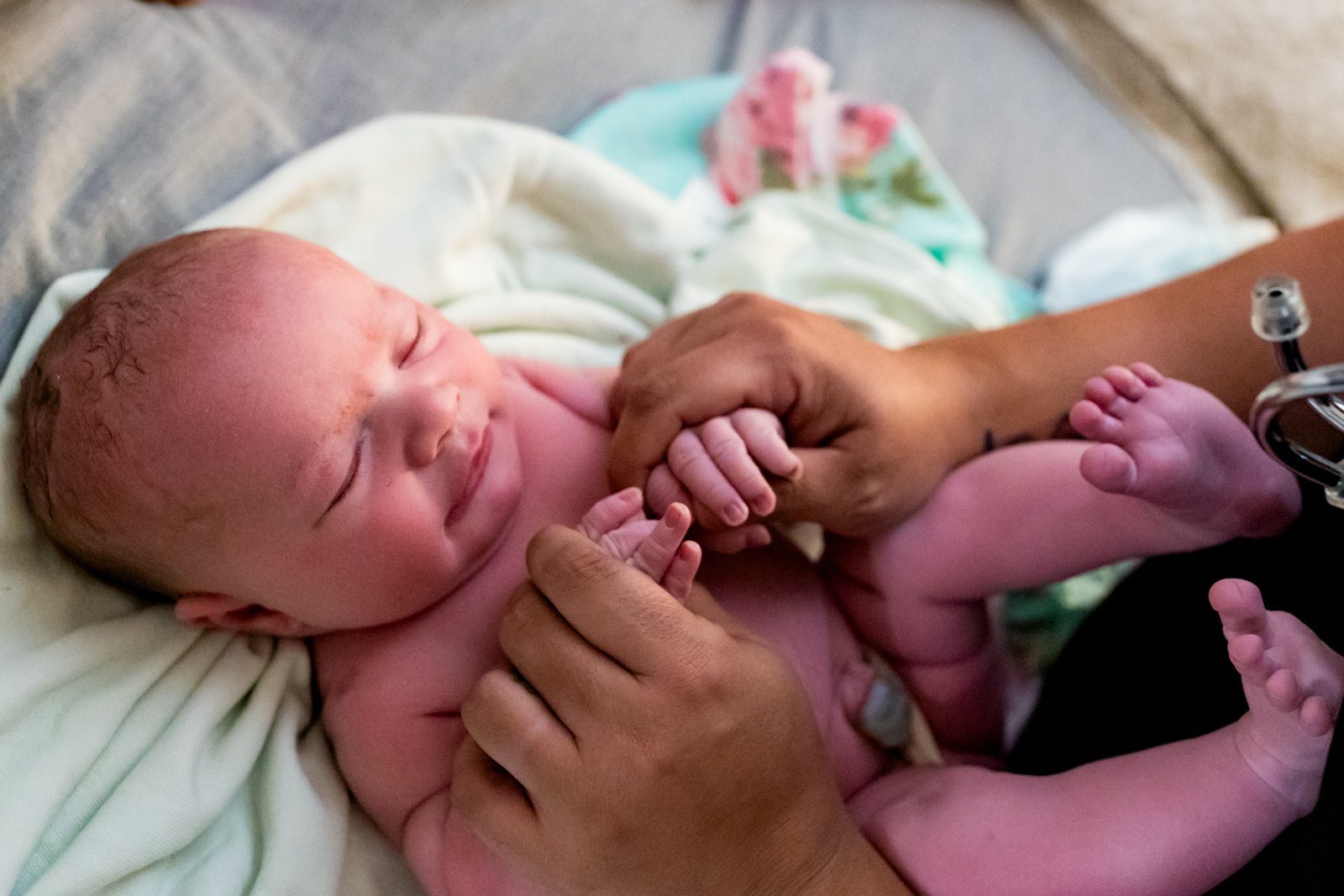 midwife assessing newborn baby's reflexes