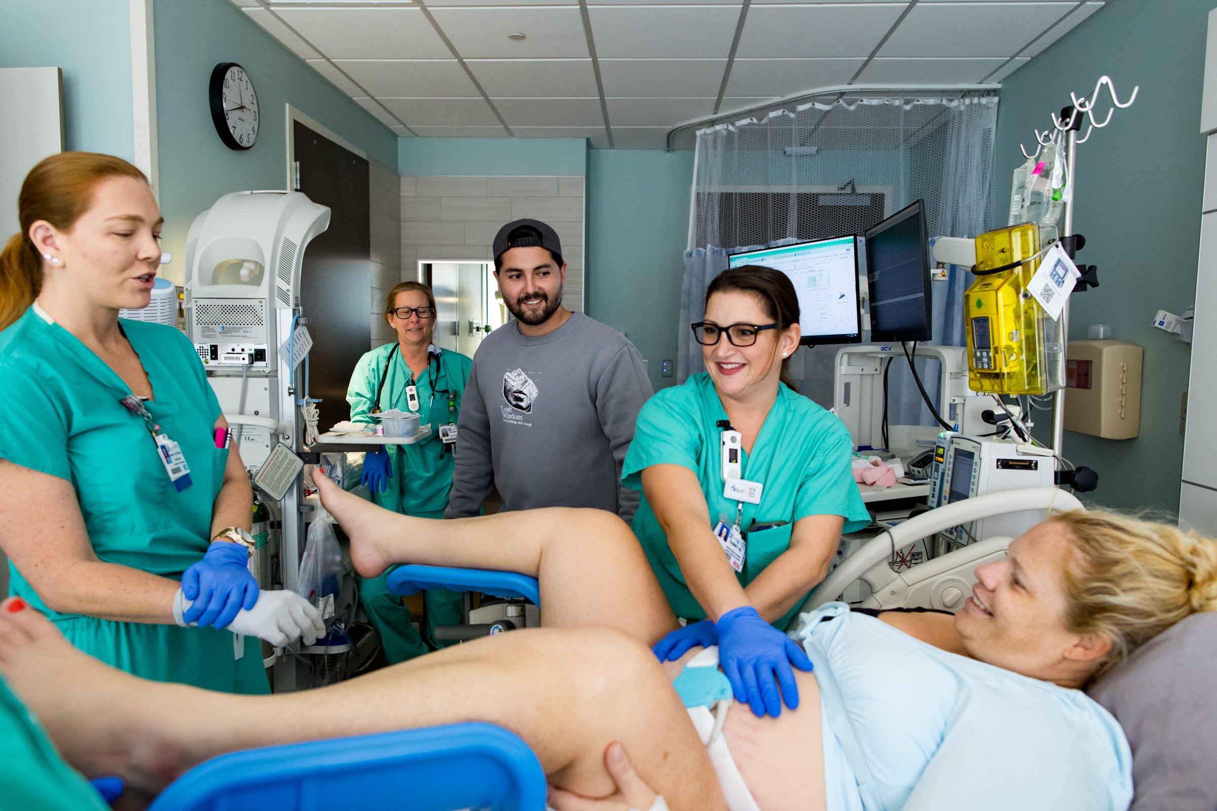 husband smiling at pregnant wife getting ready to push