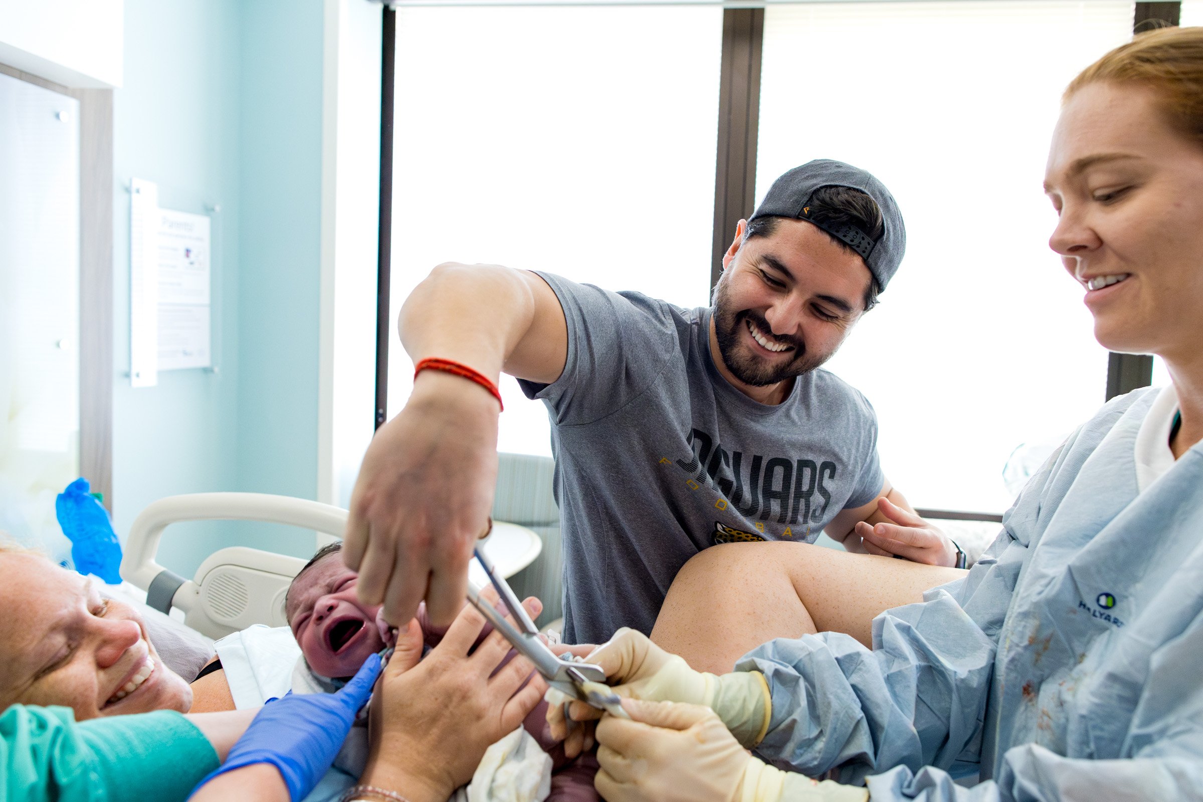 dad cutting the cord for his newborn baby girl