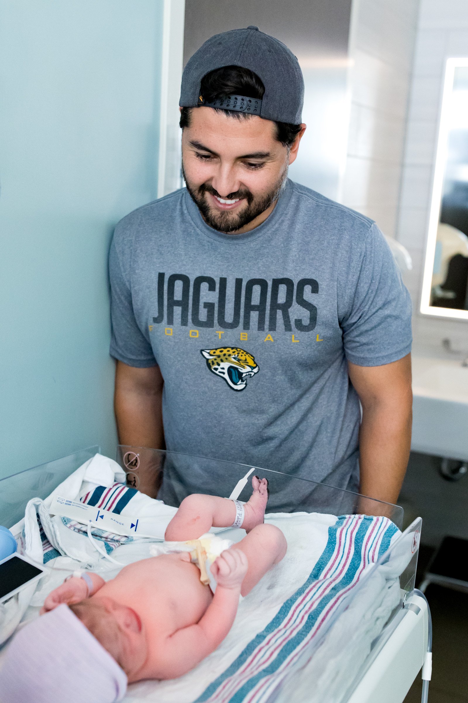 new dad looking at his newborn daughter and smiling