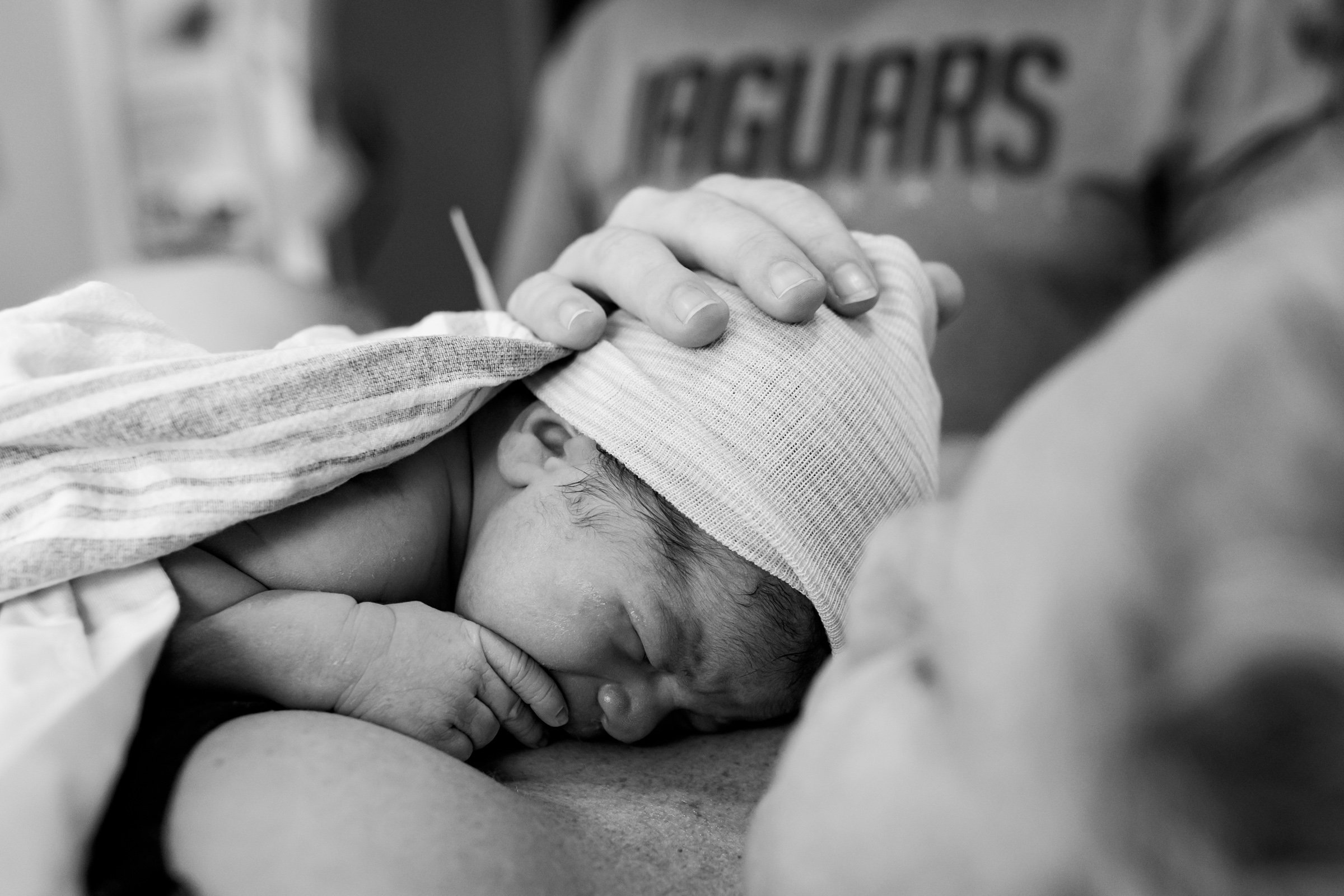 newborn baby resting on his mother's chest