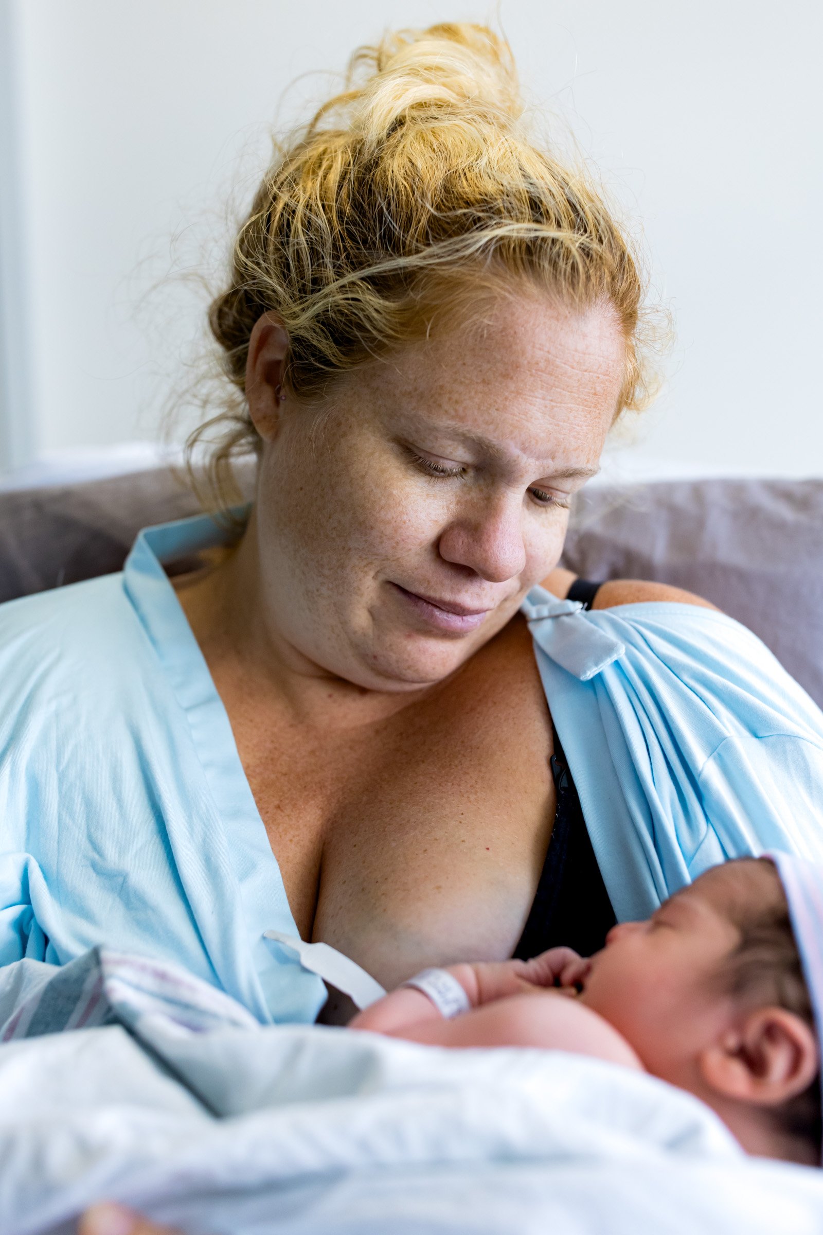 birth mom looking down at her newborn baby girl