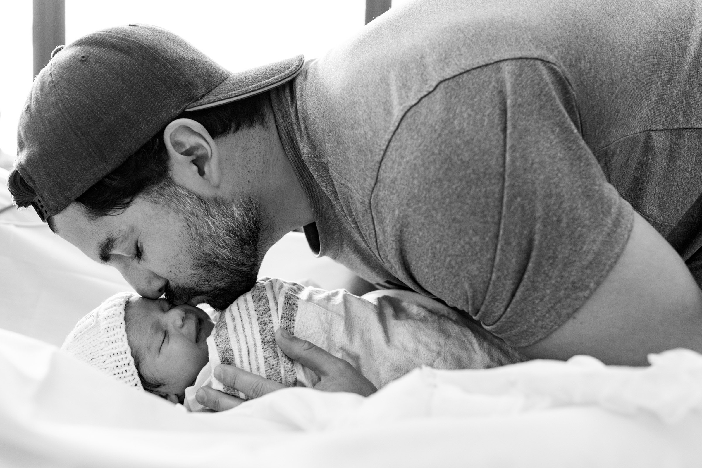 new dad kissing his baby girl just after birth