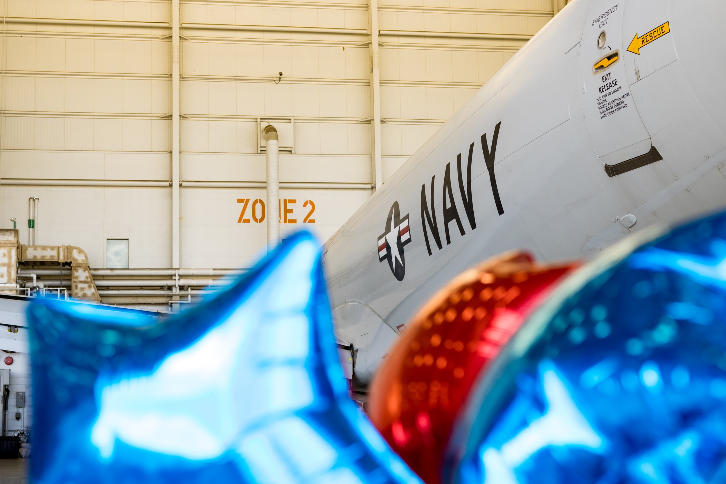 patriotic balloons near Navy plane