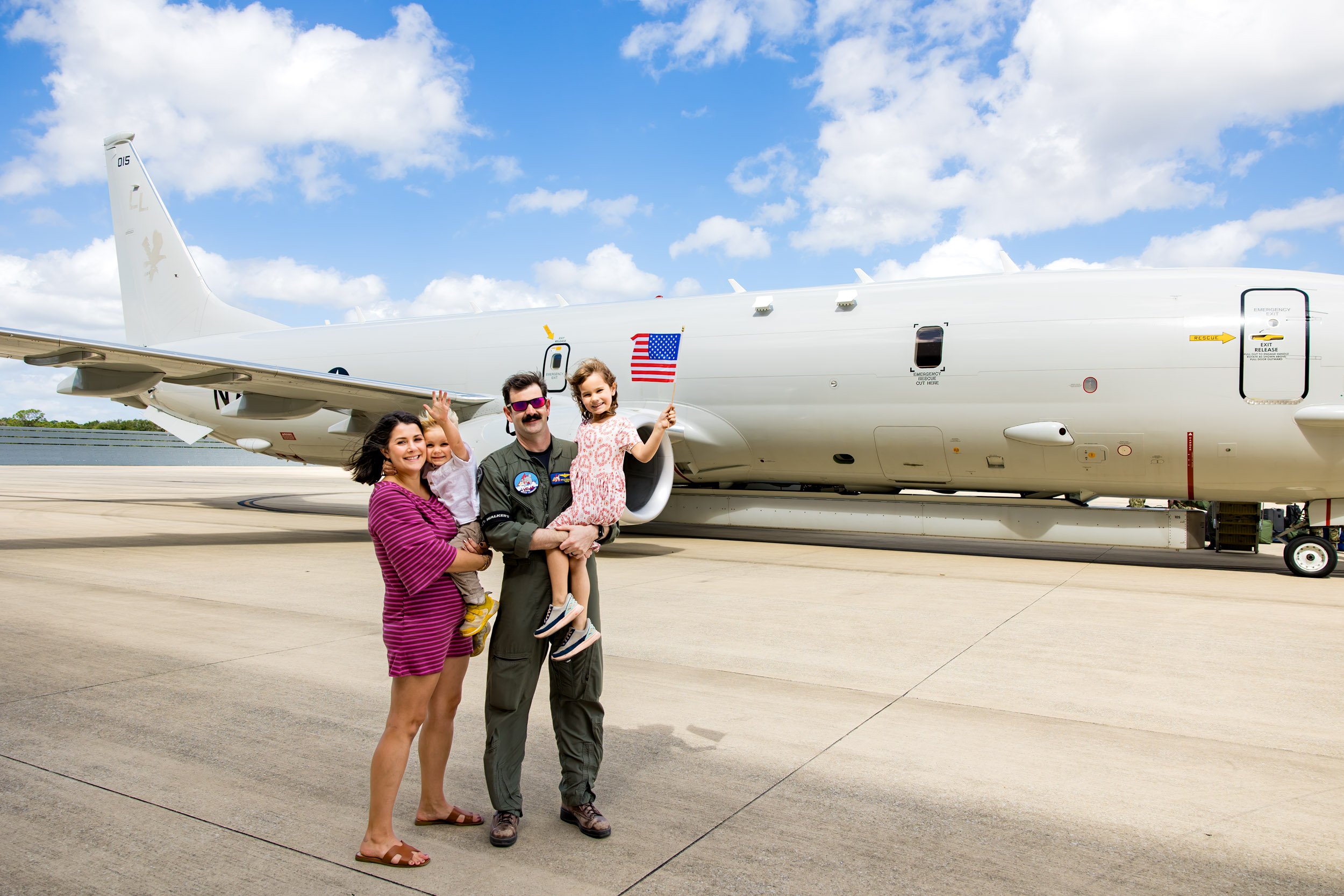military family standing in front of the plane at NAS Jax after homecoming celebration