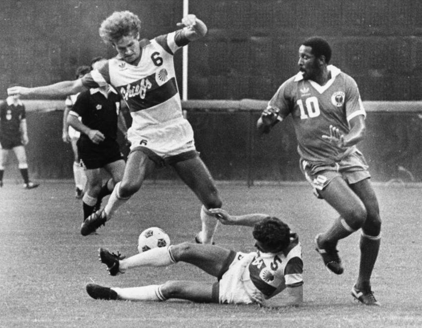Atlanta Chiefs Stuart Lilley 6 avoids a fallen teammate in a photo from the 1980s.jpg