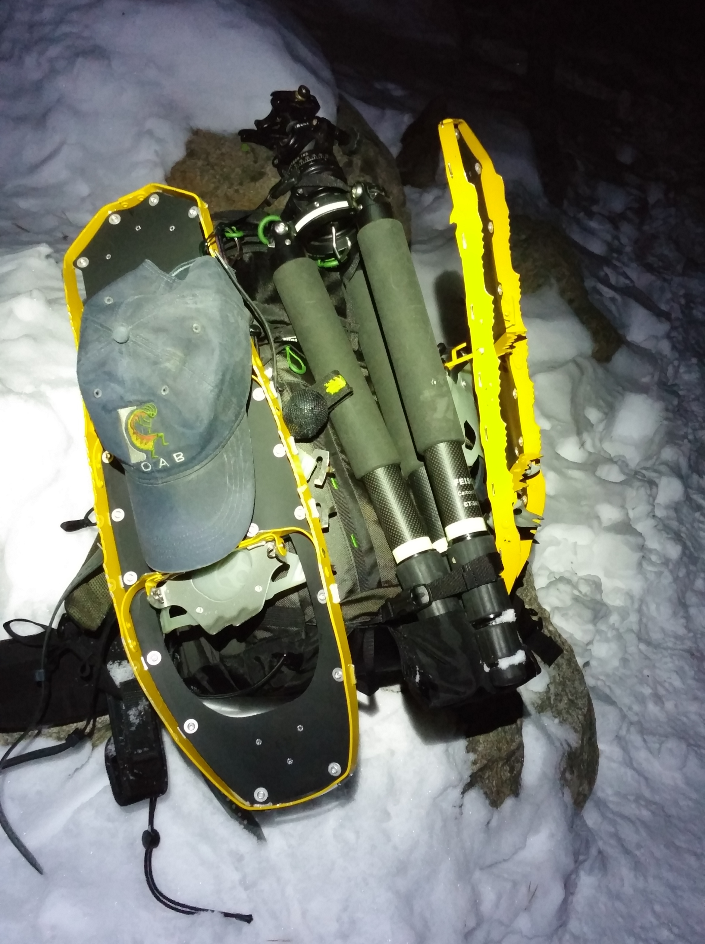 Mike has a tripod hanging on the back middle of the Backlight 26L and snowshoes on the sides.
