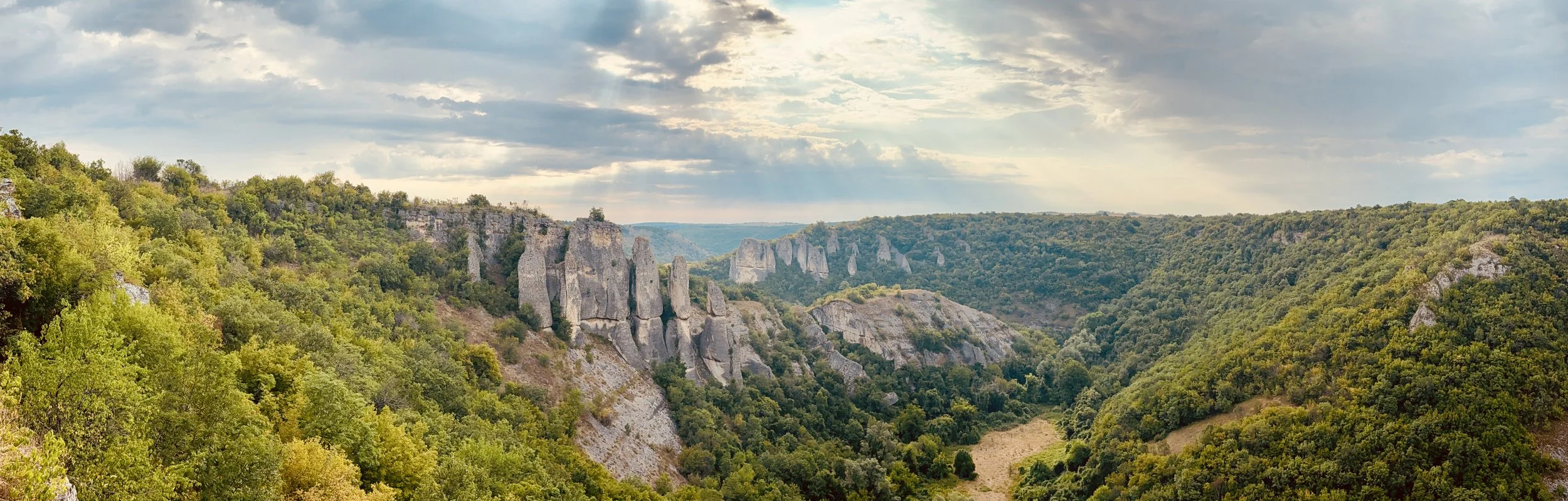 Panoramic view of dramatic limestone rock pinnacles and forested canyon in Bulgaria, photographed during filming of Naked and Afraid for Discovery Channel.