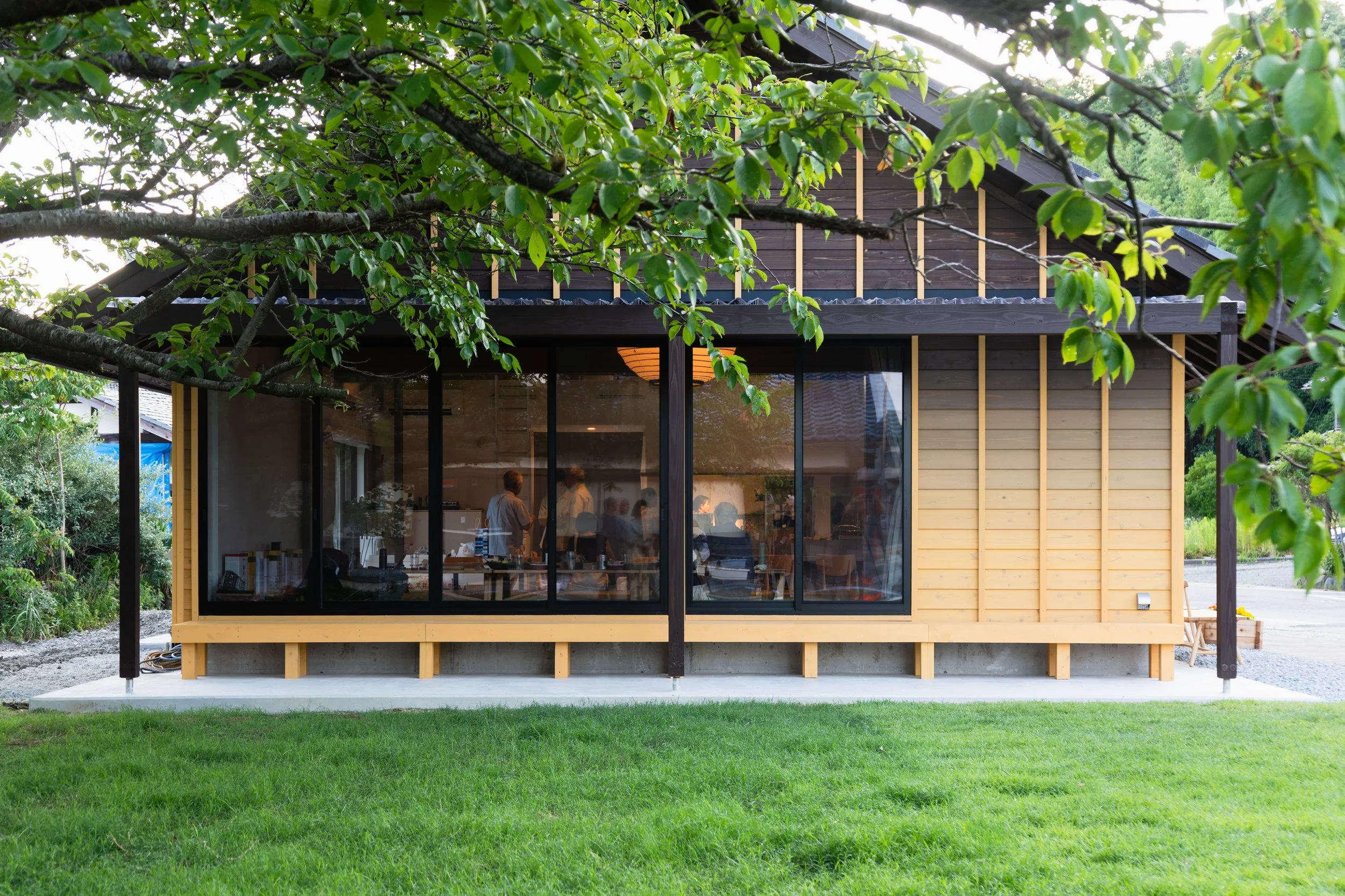  Located beside a cluster of rather soulless, prefabricated temporary housing units, the Home for All offers a contrasting sense of care, humanity, and belonging. The design draws from local traditions, using reclaimed  kawara  roof tiles and timber 