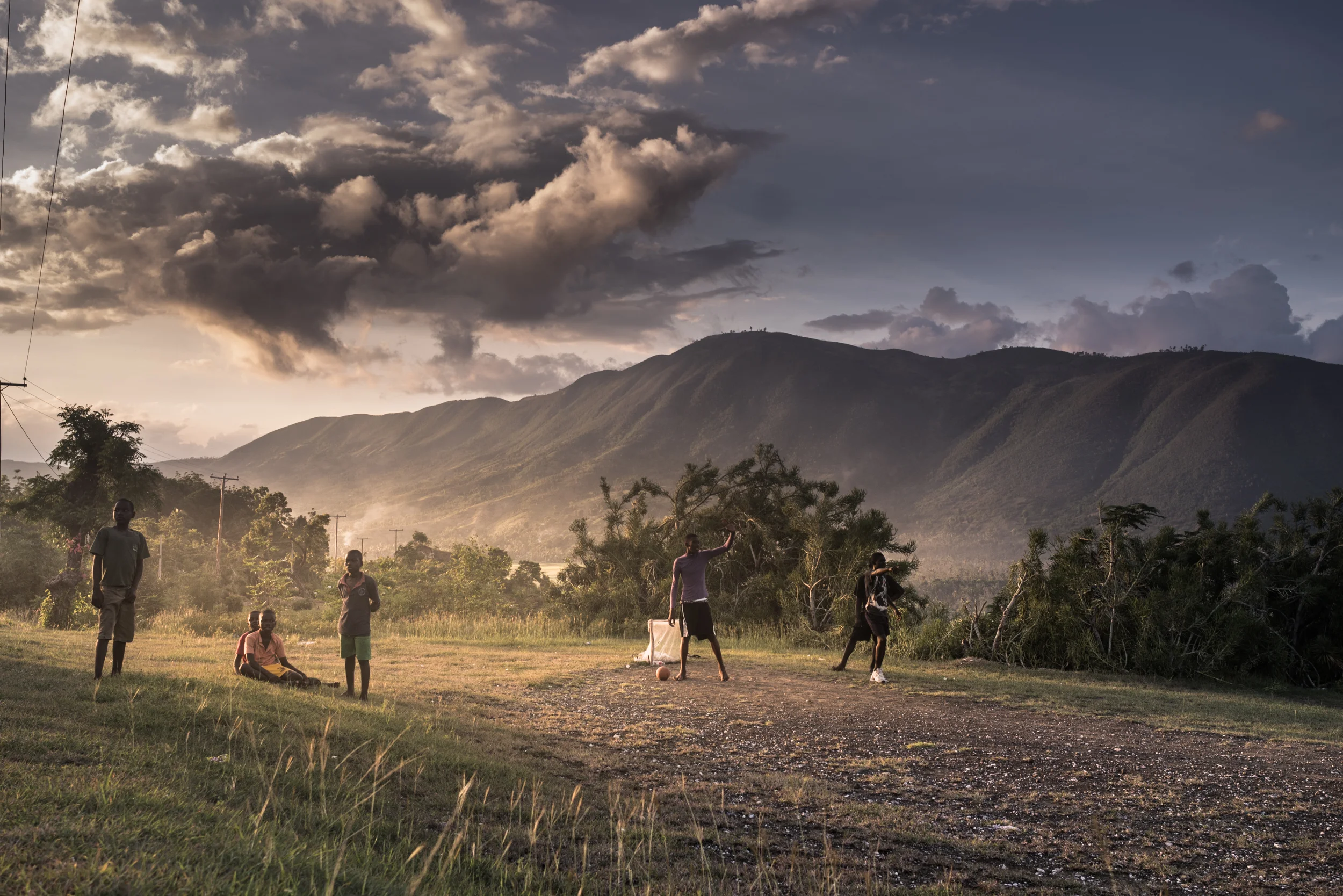 Kids play soccer at dusk. 