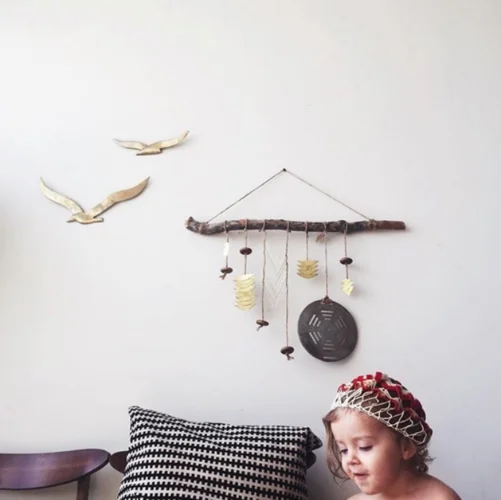 Harper plays beneath a brass + wood Electric Sun Creatives mobile