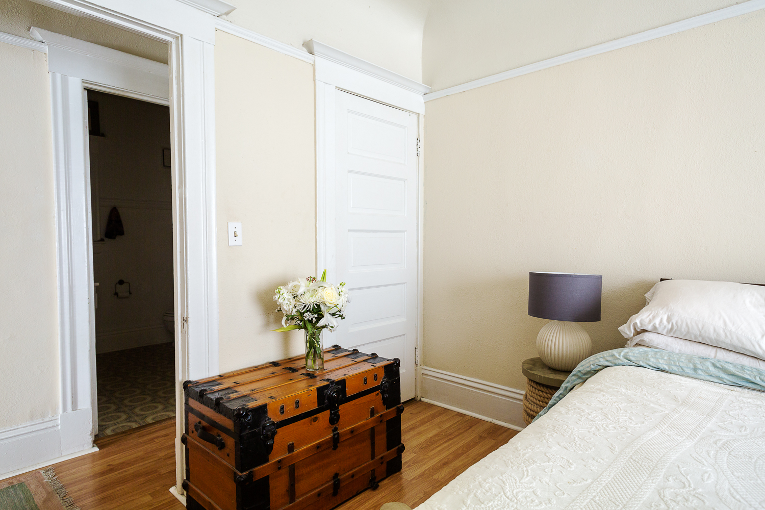  Flowers from friends atop an antique trunk. Rope spool bedside tables made by Edie's dad. 