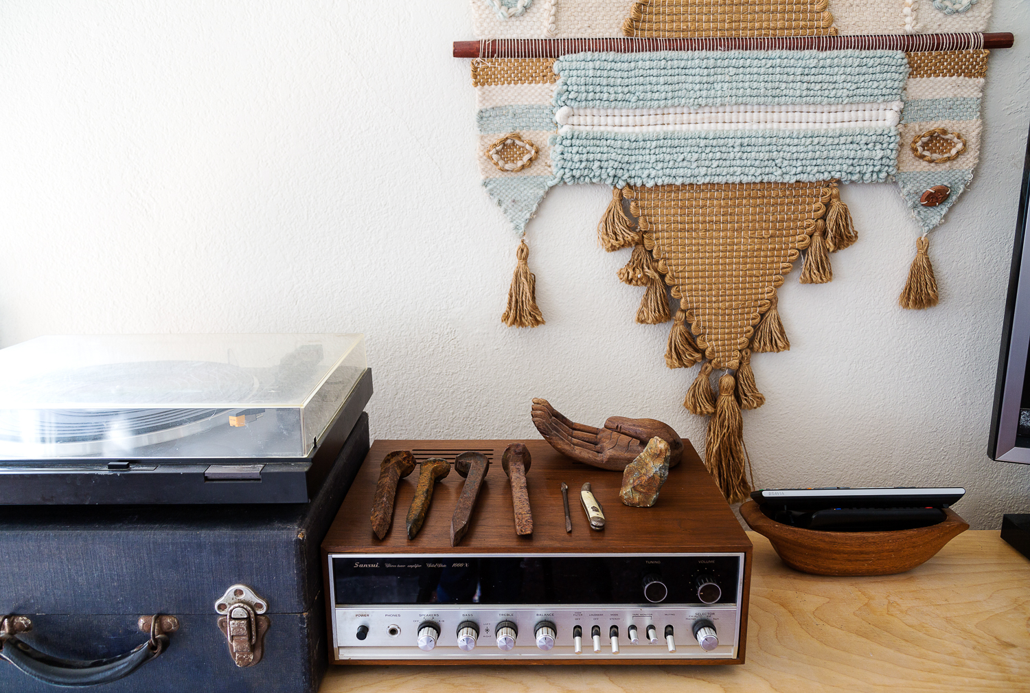  A vintage record table vignette. Flea-found railroad spikes, wooden palm, and an original Don Freedman fiber wall hanging from the '70's. 