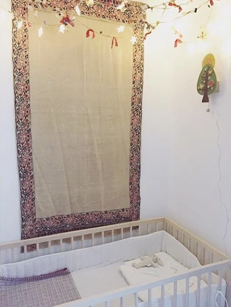 Vintage tapestries, crisp bedding, and sweet garland await baby # 4.