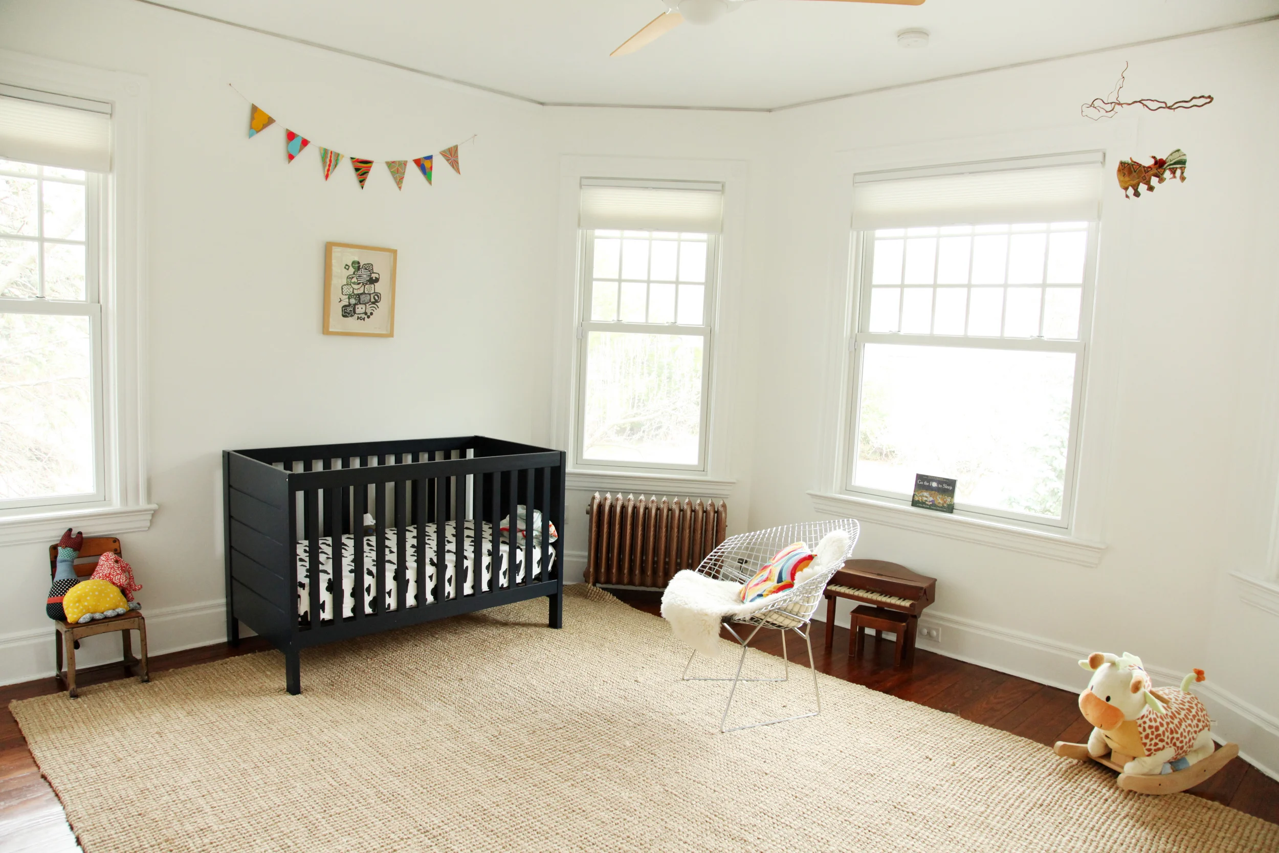 "I found the vintage school chair in my grandparents' attic along with the vintage children’s Schoenhut piano that has wooden keys!! The stuffed animals on the chair are made by Thomas and I. Land of Nod bedding. The crib is actually from Walmart. Vintage Bertoia diamond chair given to us as a house warming gift when we bought our first place in Brooklyn. 