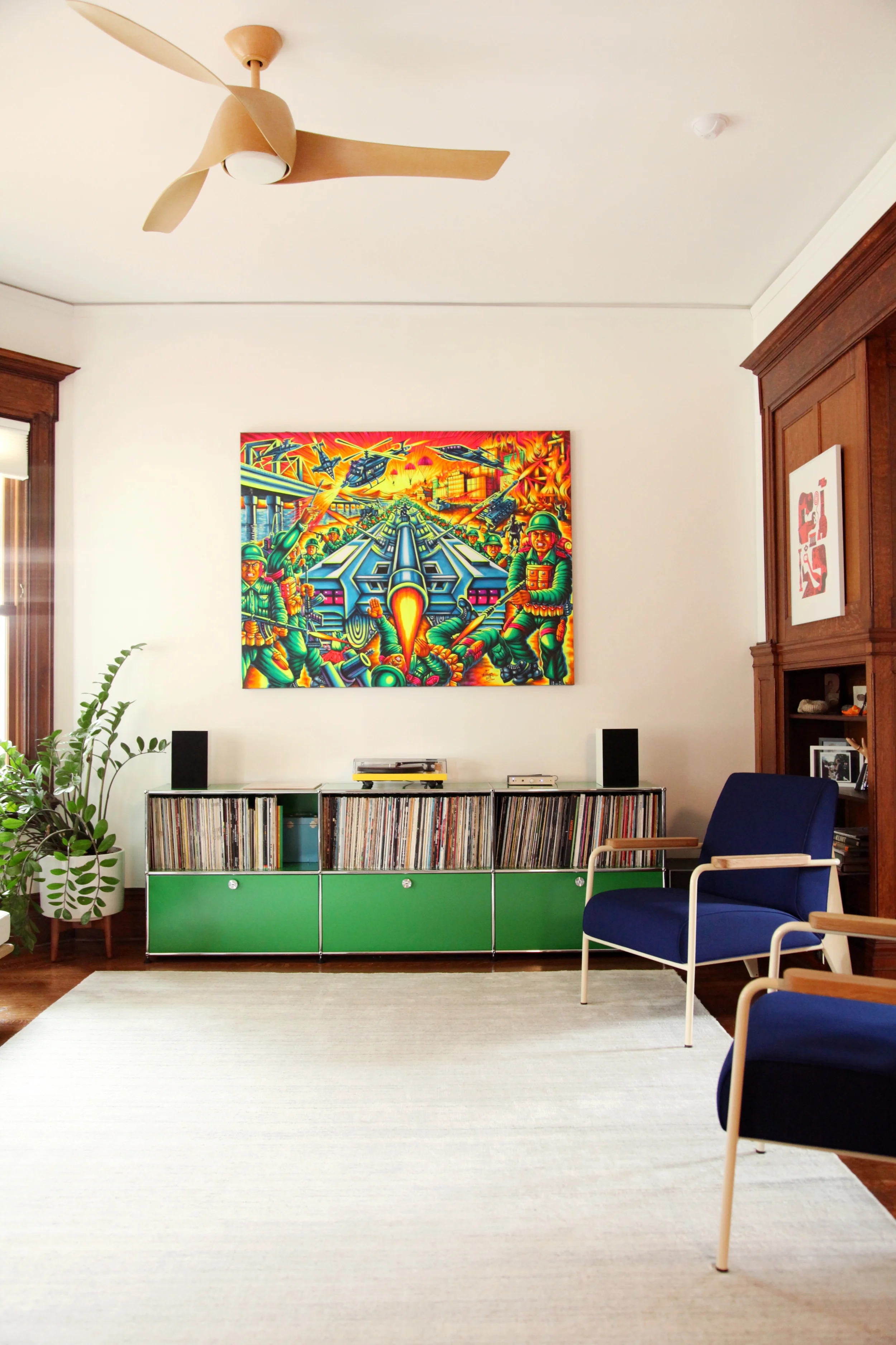 The record cabinet is by USM Haller . The large war painting is a traditional sound system Pico painting Danielle had commissioned in Columbia . The ink blue chairs are Prouvé Fauteuil de salon lounge chairs from Vitra.