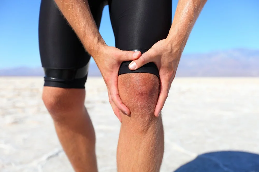 Image of a man holding his knee