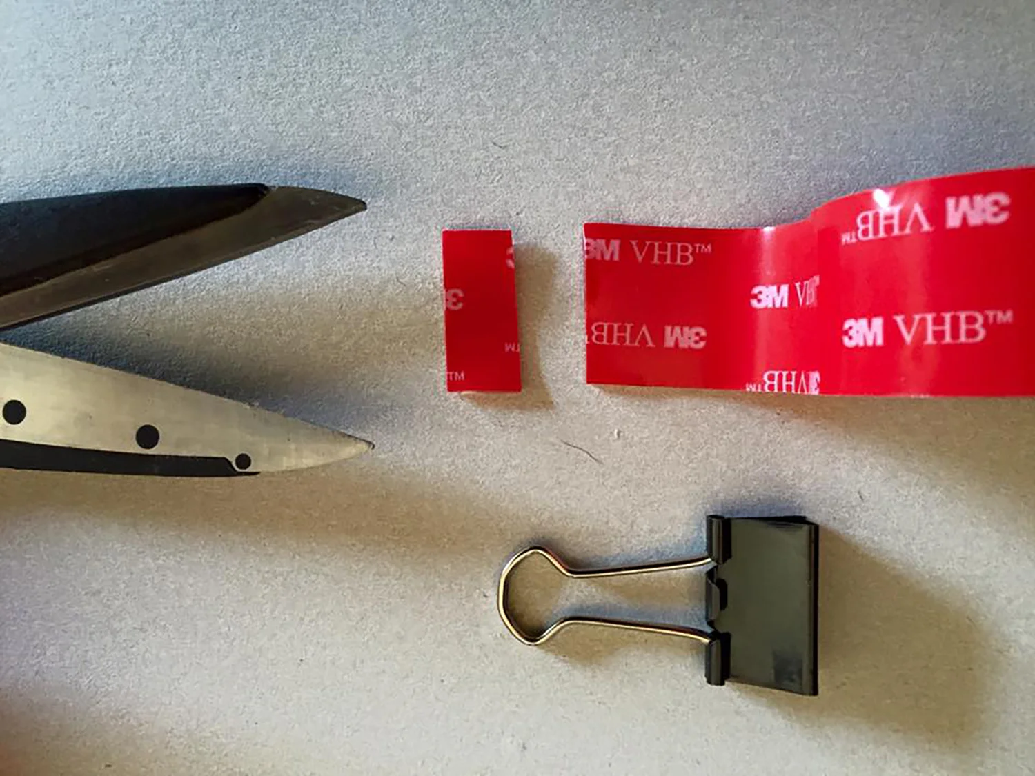 2. Cut a thin strip of adhesive tape that will fit the top of the double clip.