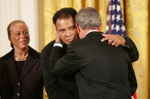 Muhammad Ali, here receiving the Presidential Medal of Freedom in 2005, lived publicly with Parkinson’s disease for decades. Paul Morse/Wikimedia Commons (public domain)